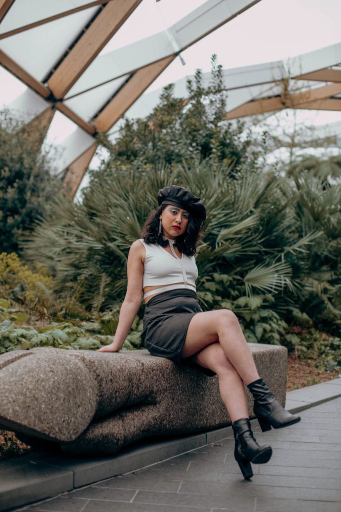 Cherie wearing a black and white sustainable outfit to combat fast fashion with a handmade matching black skirt and beret, in the Crossrail Place Roof Garden in Canary Wharf