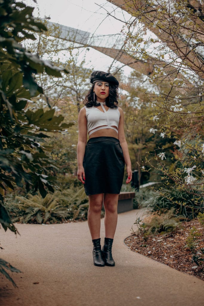 Cherie wearing a black and white sustainable outfit with a handmade matching black skirt and beret, in the Crossrail Place Roof Garden in Canary Wharf