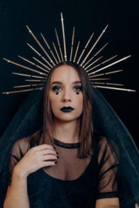 A halloween themed self portrait against a black backdrop with a gold crown and black veil.