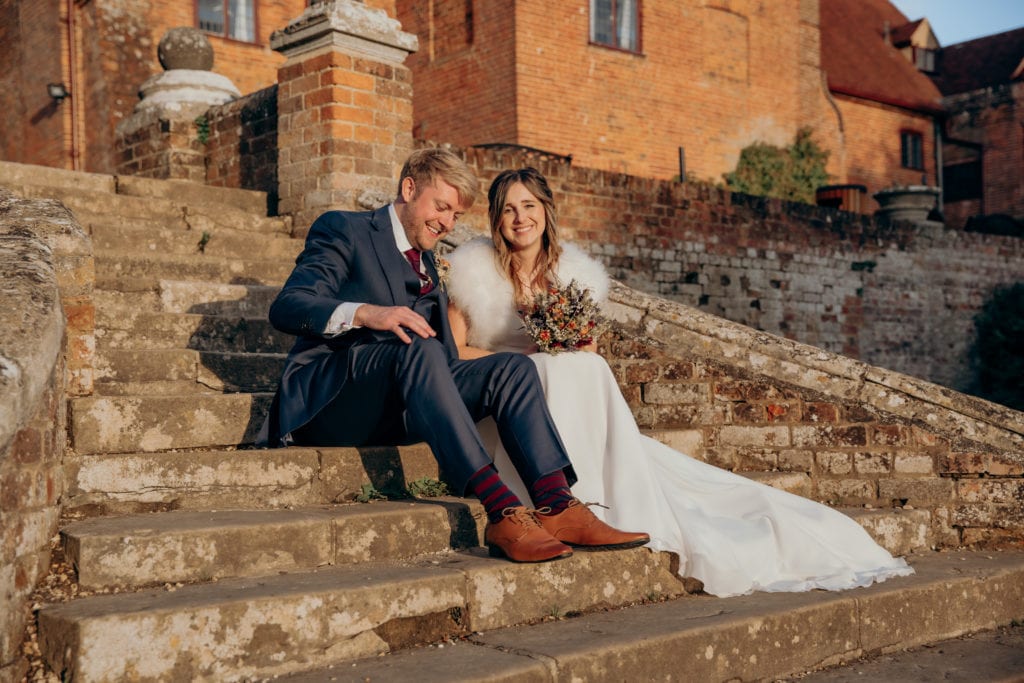 Lisa and Jason sitting on the steps of Ufton Court gardens during their wedding photography couple session