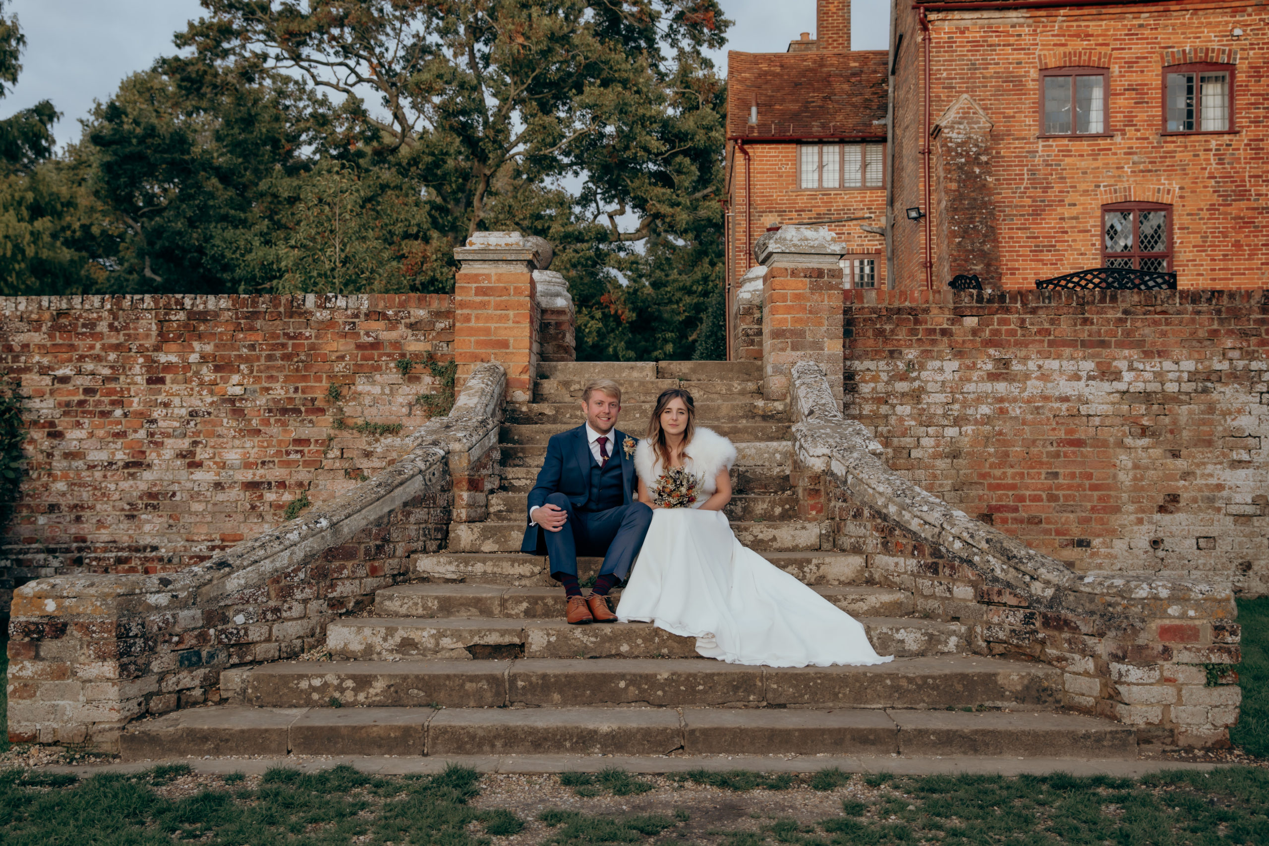 Lisa and Jason sat on the steps of Ufton Court's gardens on their wedding day
