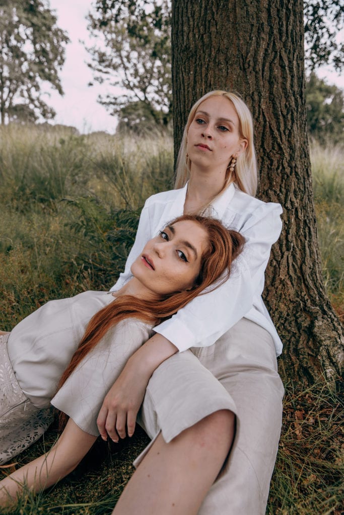 Jasmine and Amber wearing matching cream sustainable outfits in Richmond Park, London