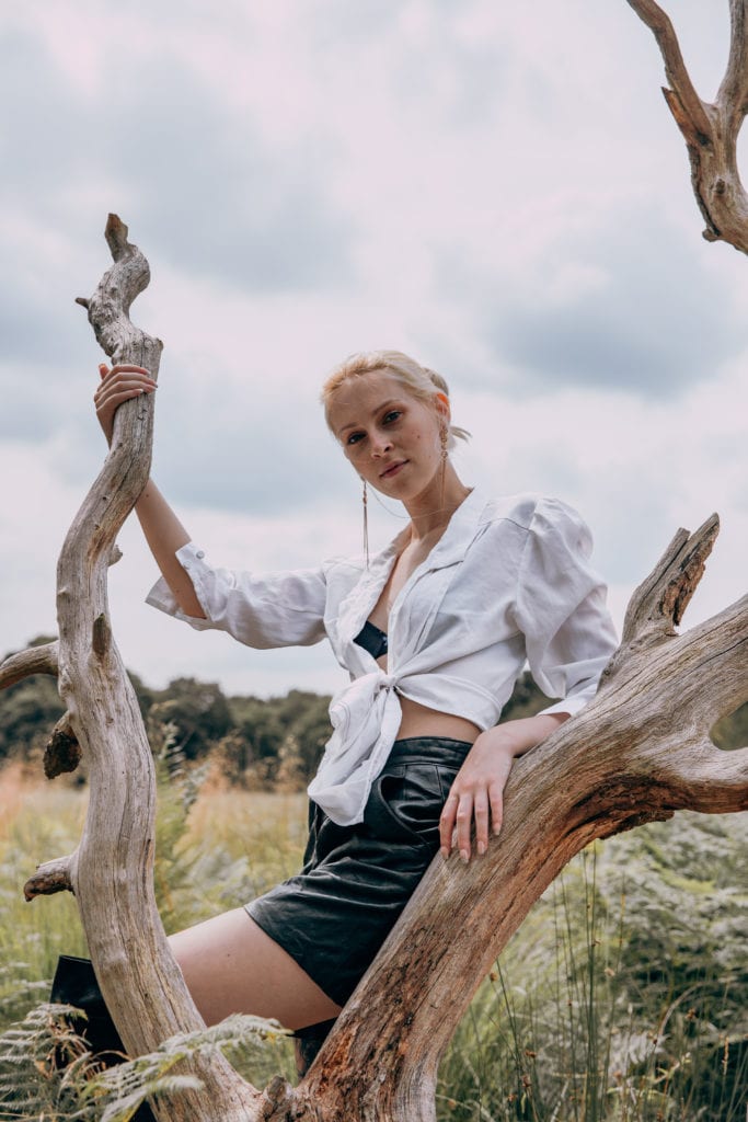 Amber wearing black shorts and a white blouse in Richmond Park, London