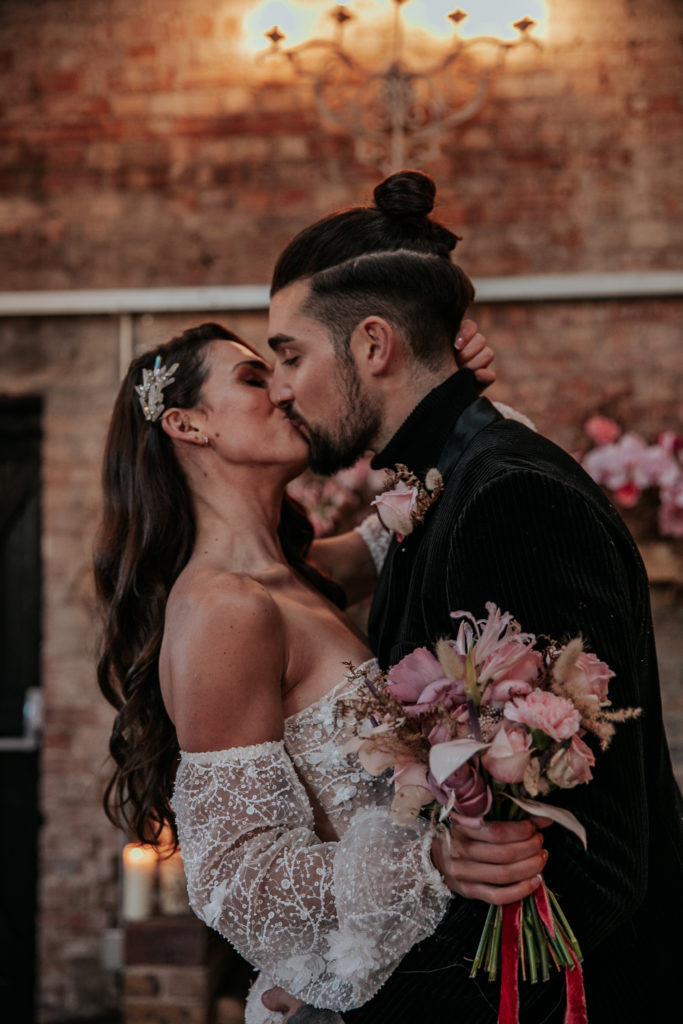 Jacob and Tomina stood at the altar in the Oakley Barn as gold confetti falls around them, surrounded by candles and pink flowers