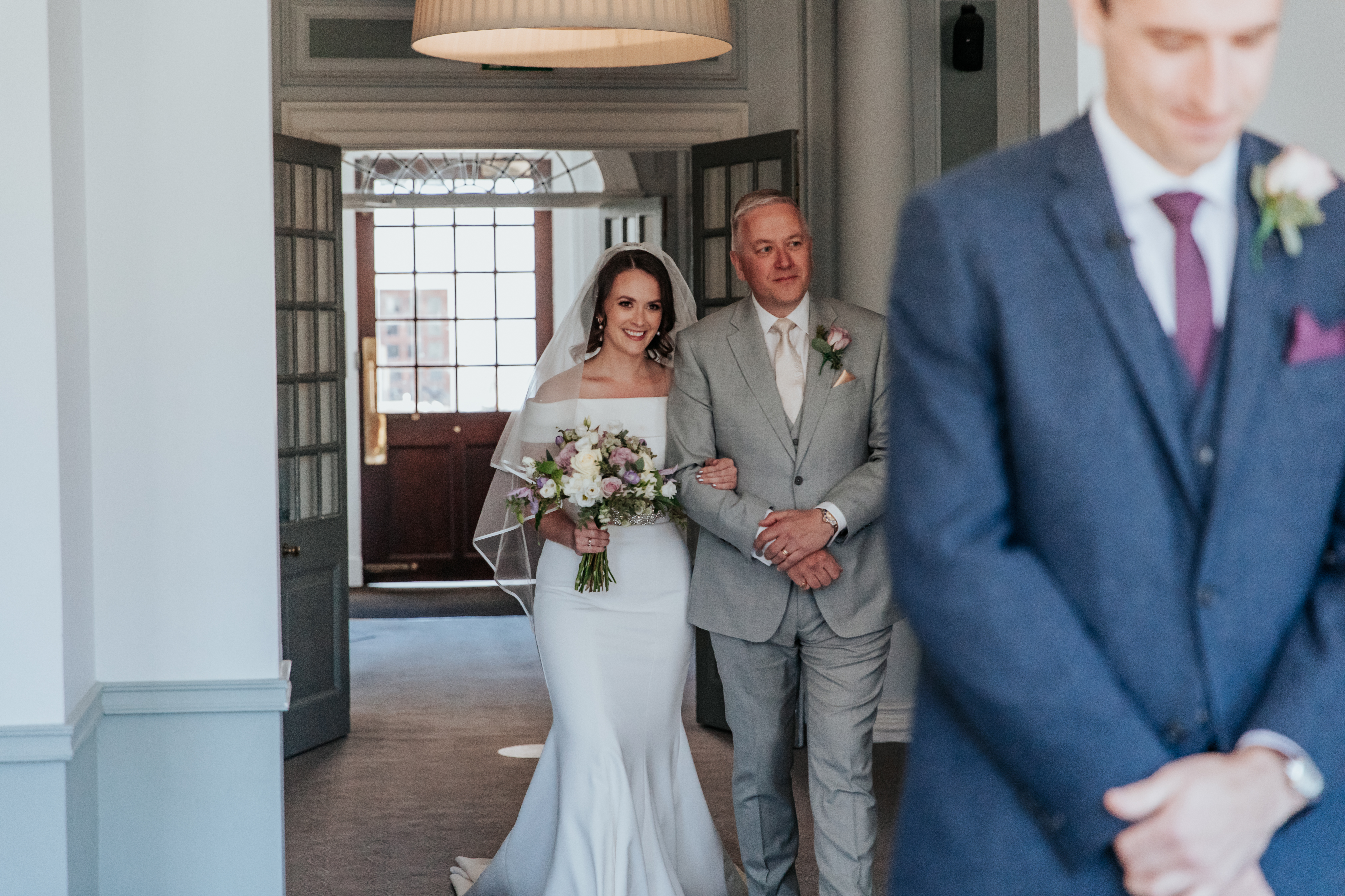 Laura's dad walks her down the aisle during their microwedding ceremony