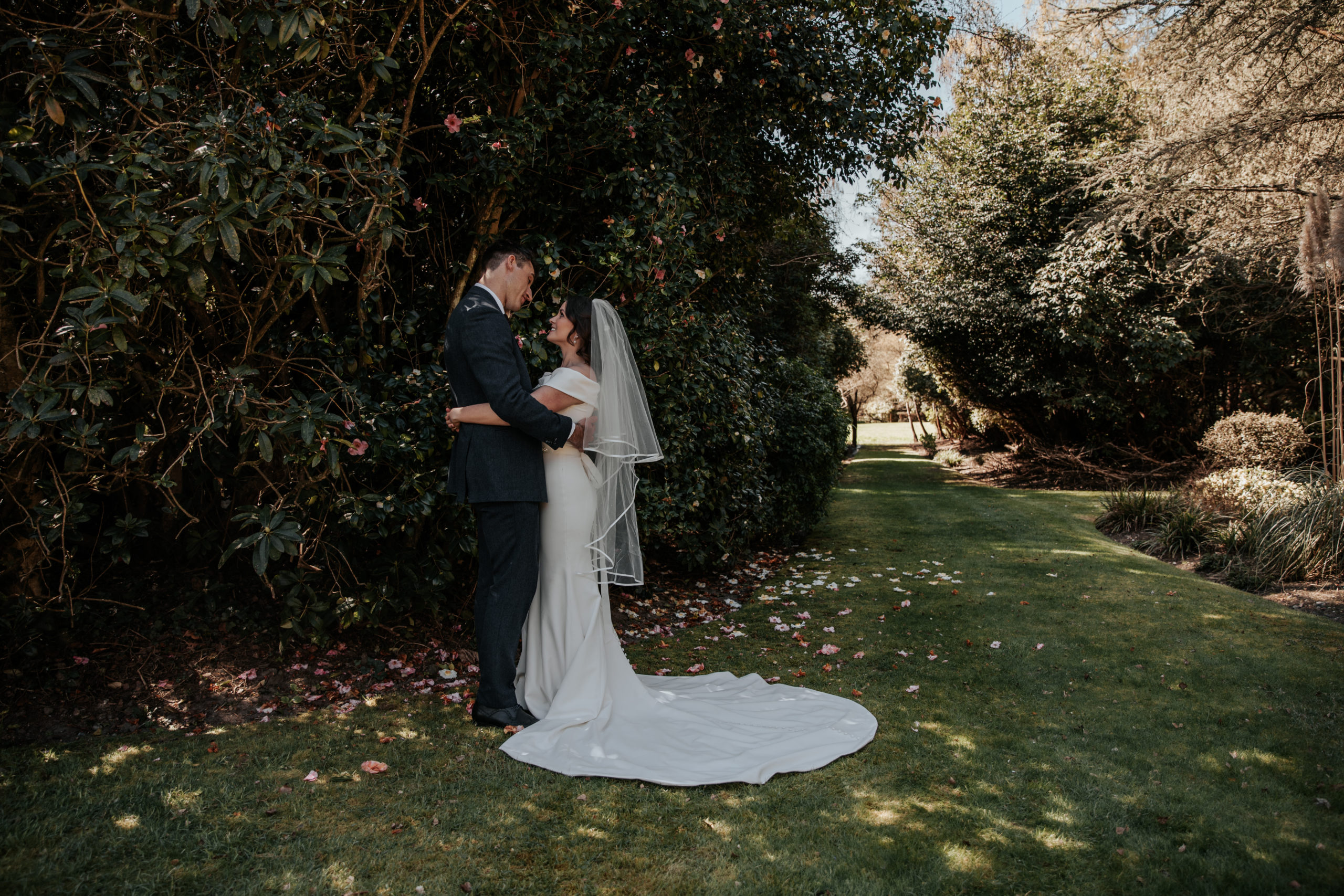 Laura and Stuart embrace in the gardens during their Gorse Hill wedding