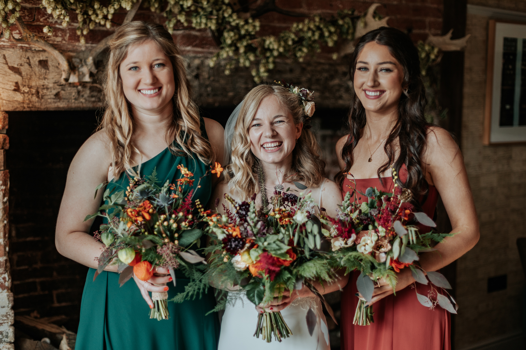 Maddie stands with her two sisters, smiling and holding their bouquets