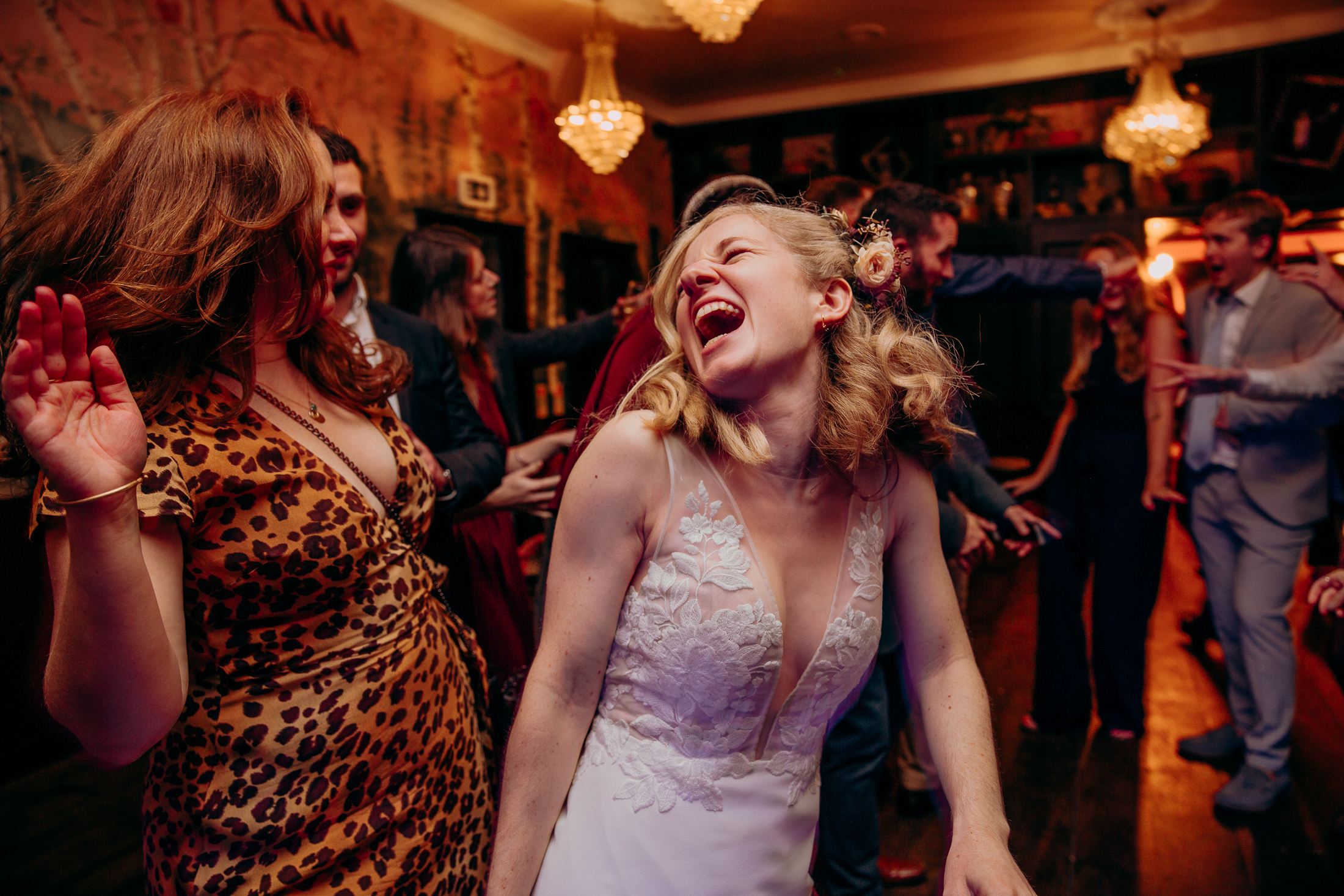 Maddie dances with a friend at her wedding reception in her chic wedding dress