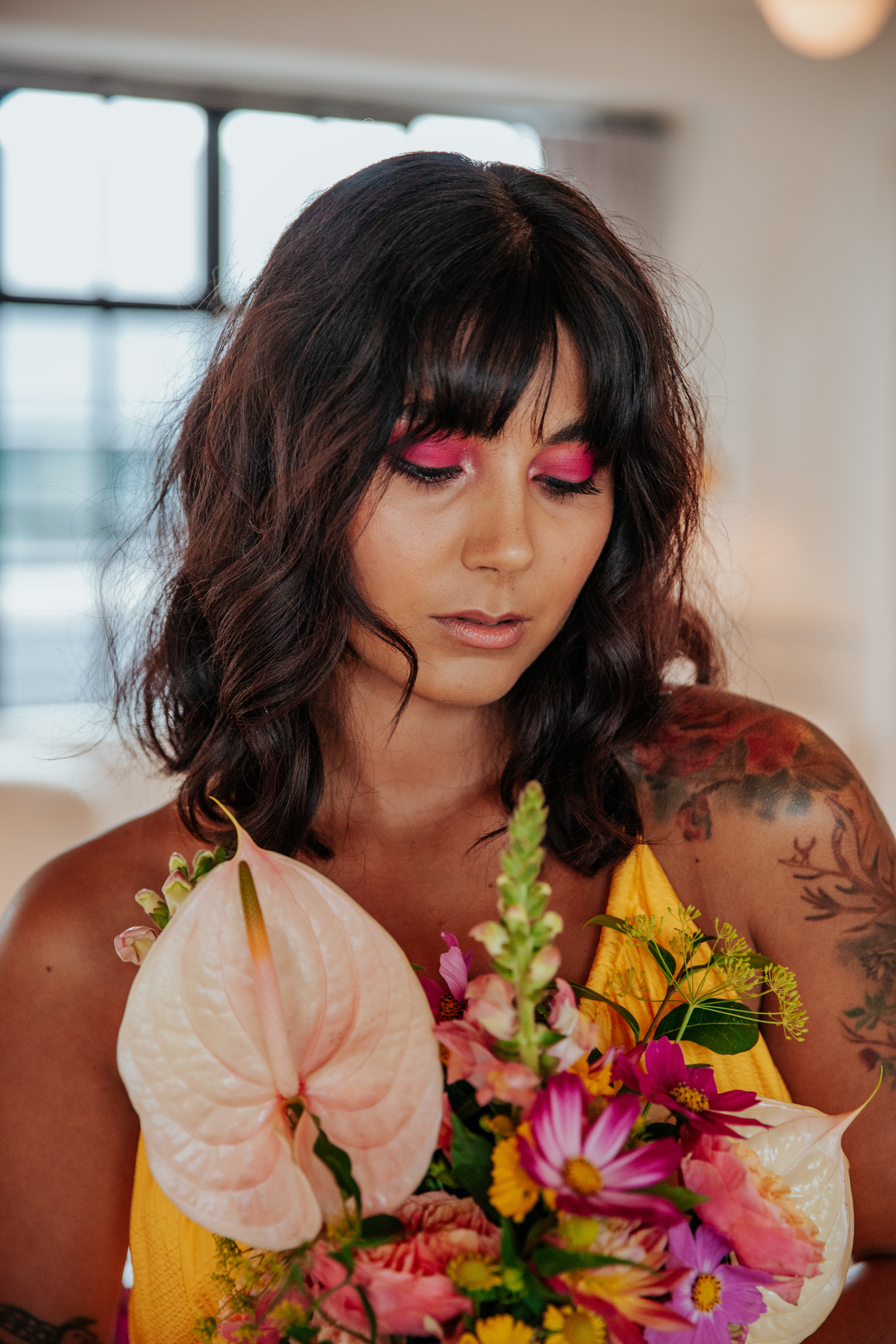 Meera looks down at her wedding bouquet, and you can see her hot pink eyeshadow pop