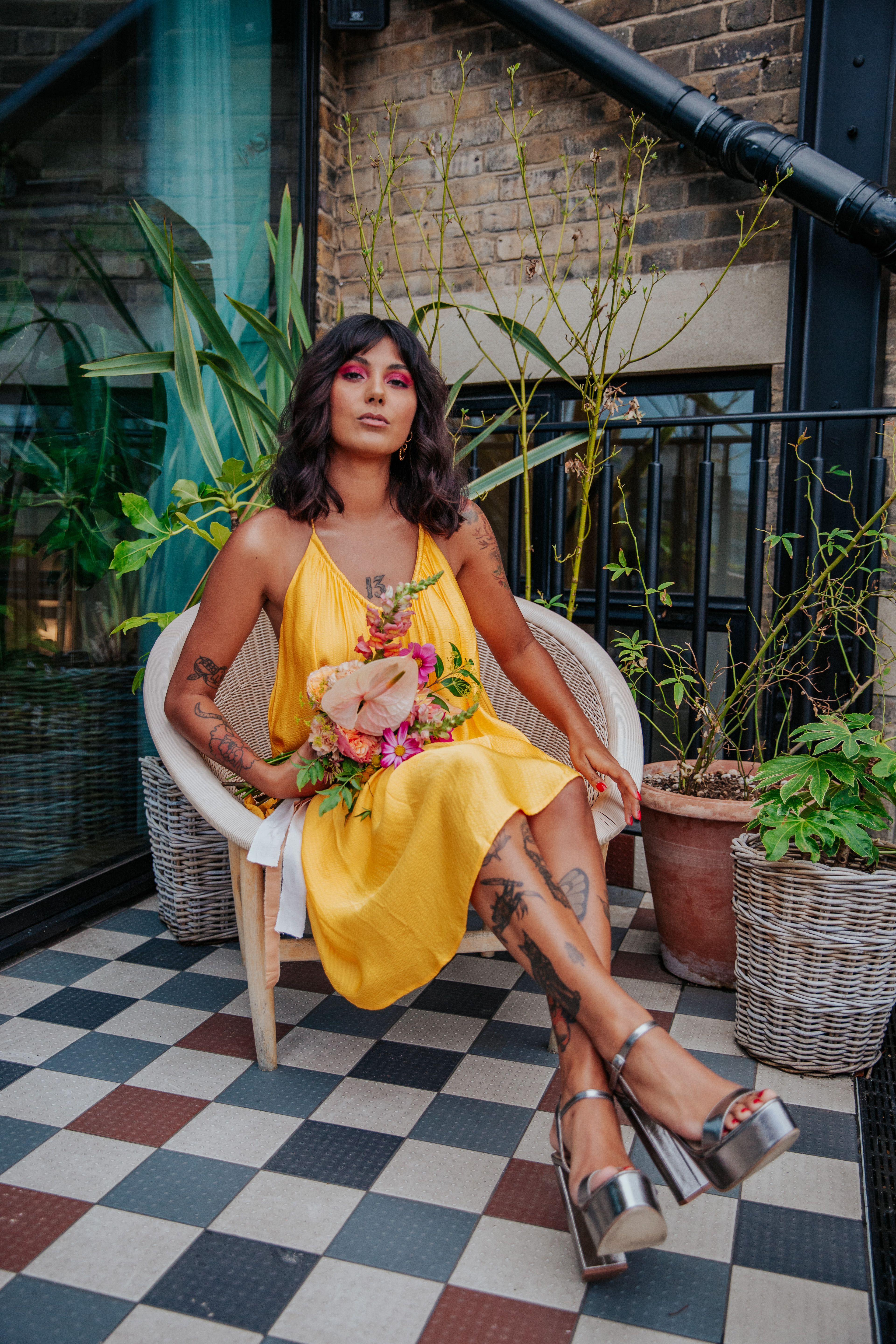 Meera sits on the balcony of Mortimer House with her bouquet for a London microwedding photoshoot