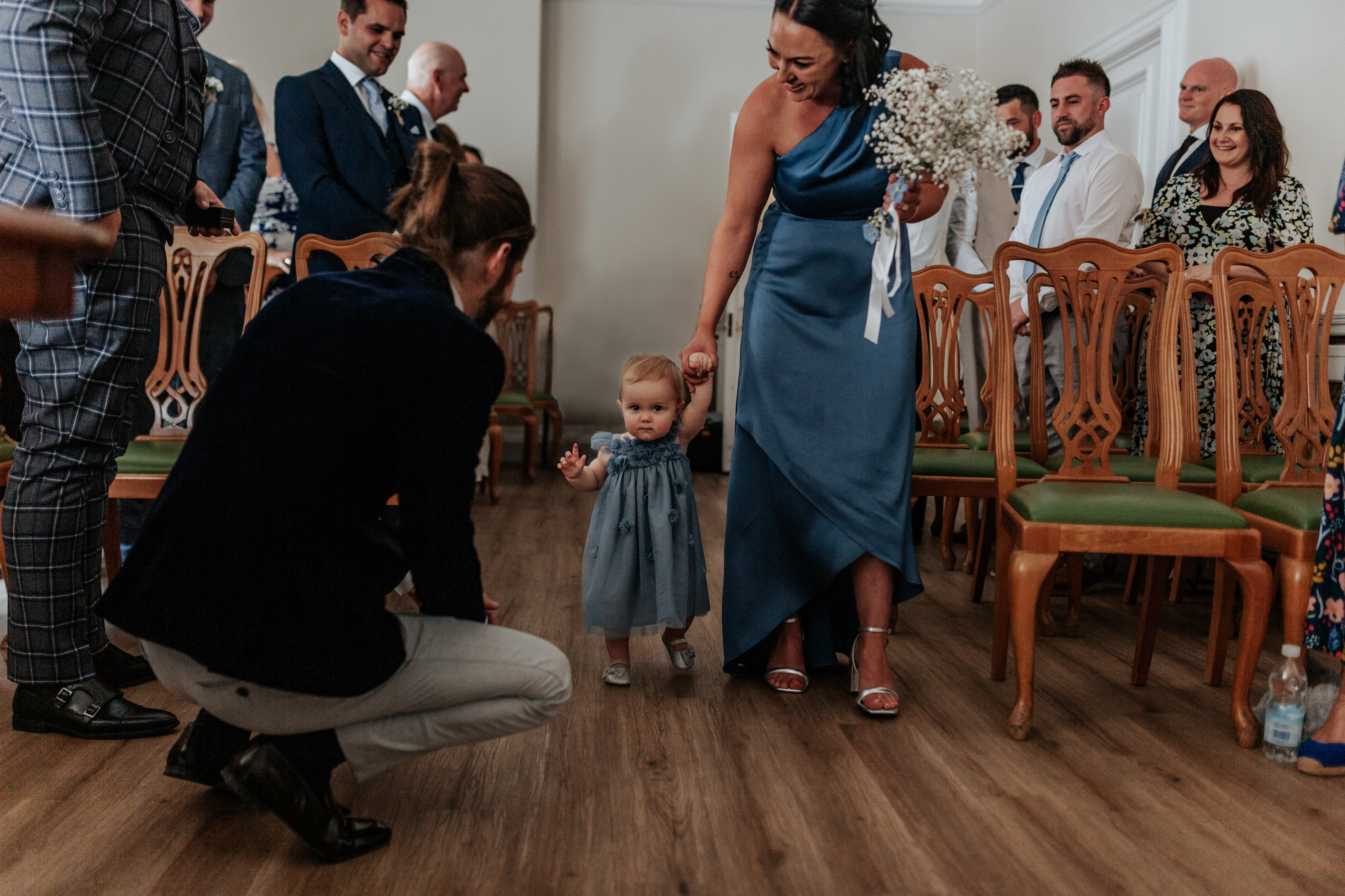 HannahSam25_07-028 Toddler and bridesmaid in blue matching dresses walk down the aisle