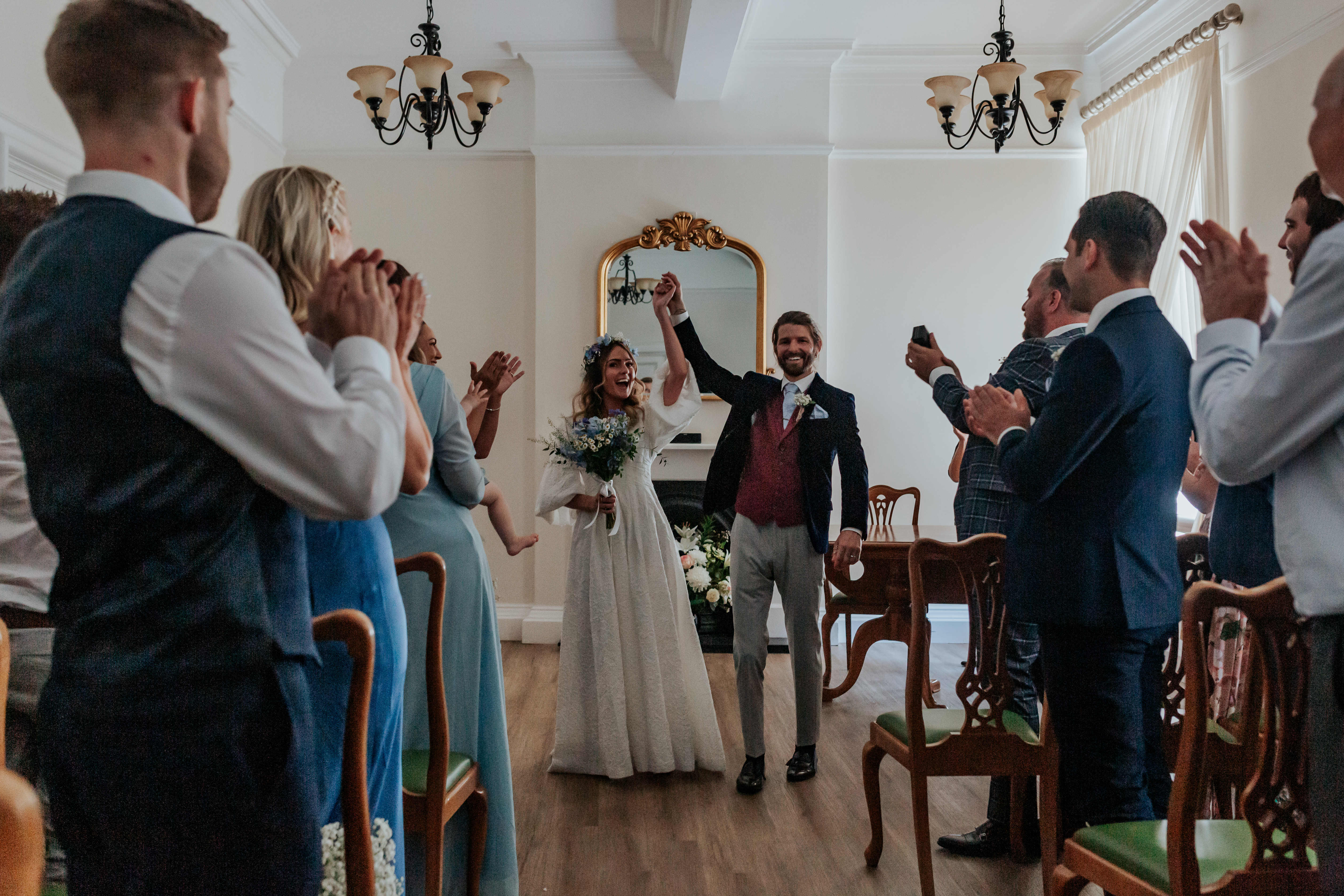 HannahSam25_07-090 Bride and groom walk back up the aisle with their hands in the air