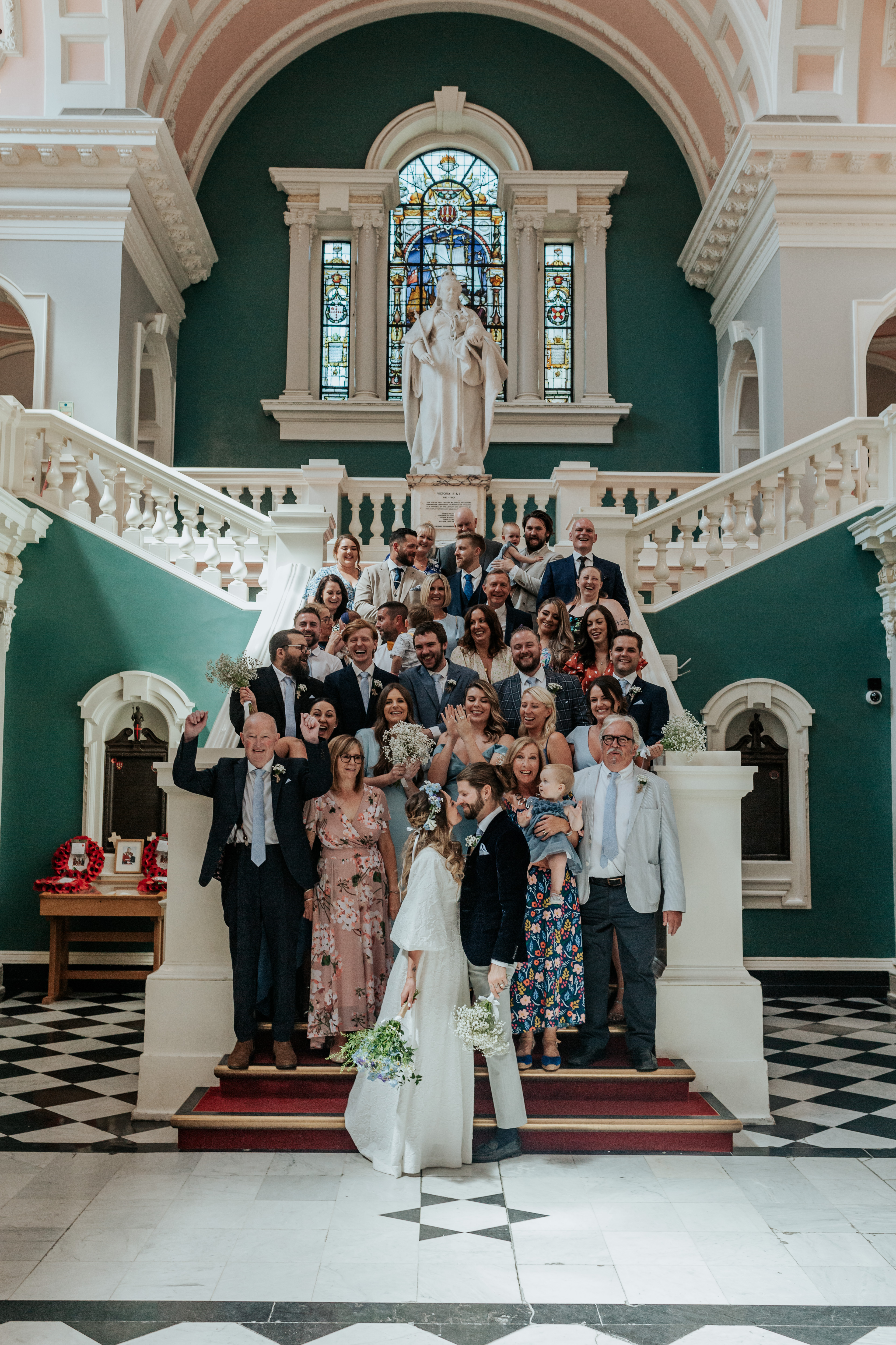 HannahSam25_07-103 A full group photo of all London wedding guests on the stairs of Woolwich Town Halll