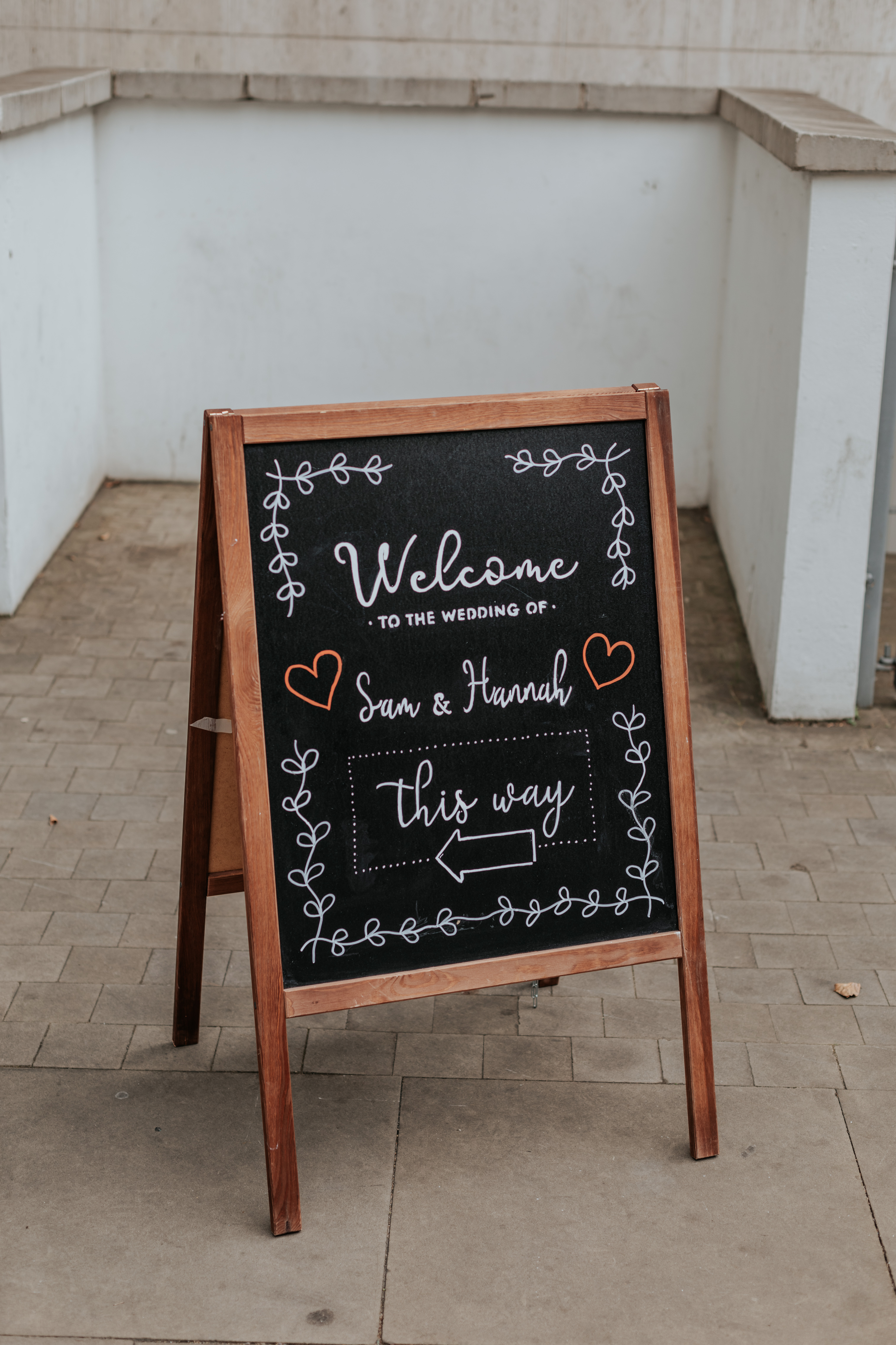 HannahSam25_07-139 A wooden chalkboard sign pointing the way to the wedding