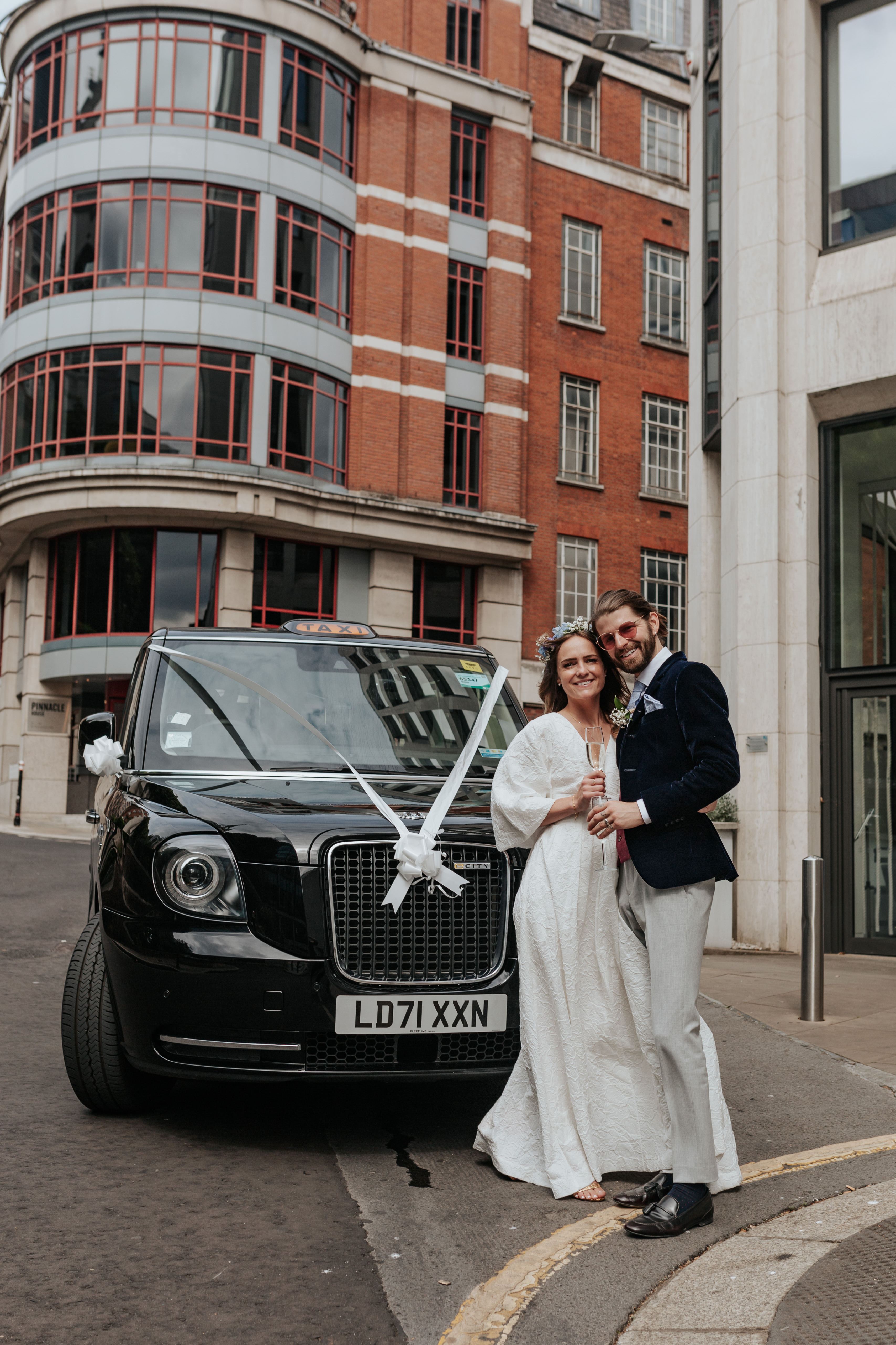 HannahSam25_07-140 Bride and groom pose infront of their decorated black cab during their London Wedding