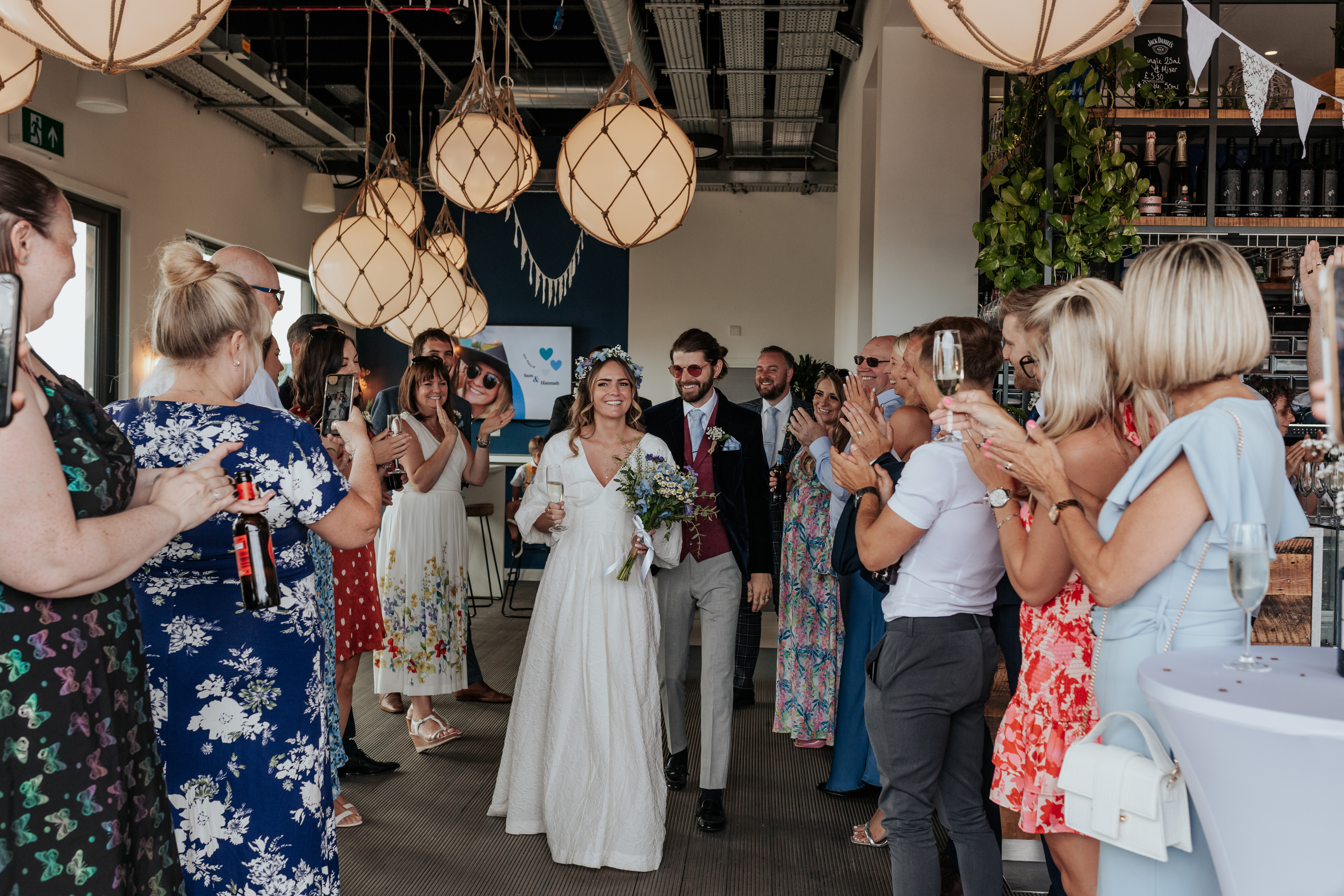 HannahSam25_07-145 Bride and groom make their entrance into their wedding reception in a rooftop London bar