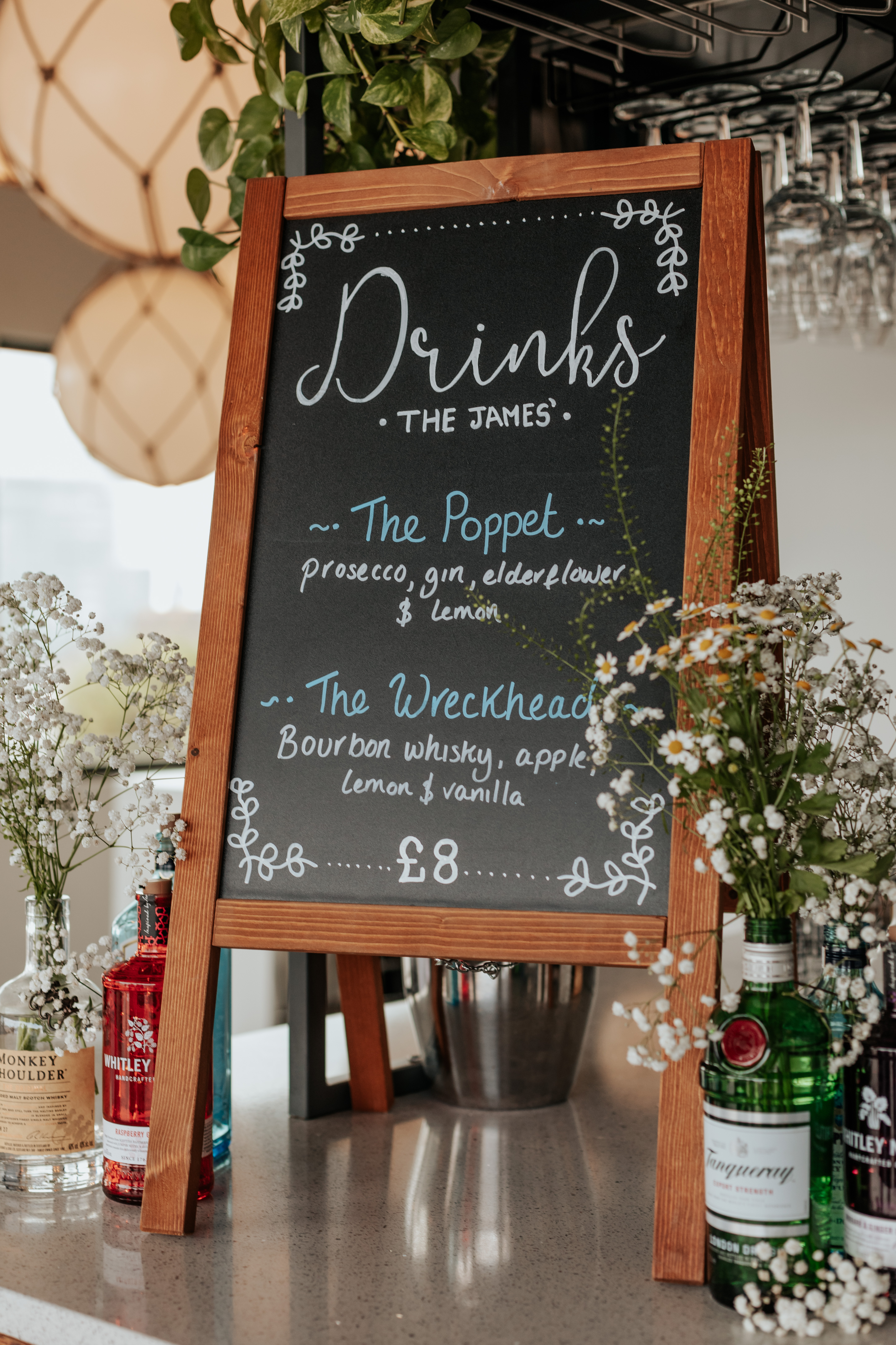 HannahSam25_07-148 A wooden chalkboard sign with the bride and groom's custom cocktails