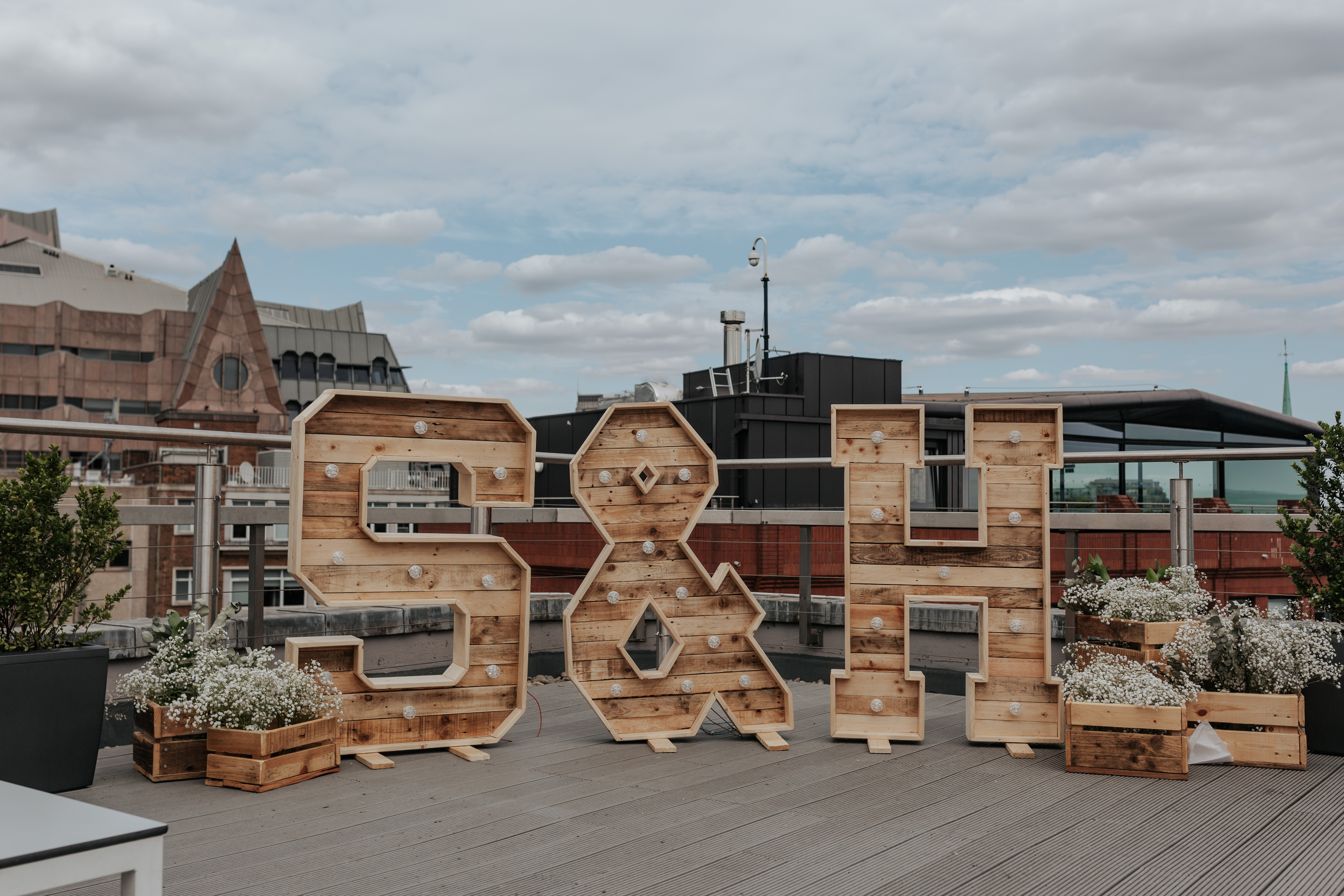 HannahSam25_07-149 S & H in giant wooden light up letters overlooking the London city skyline