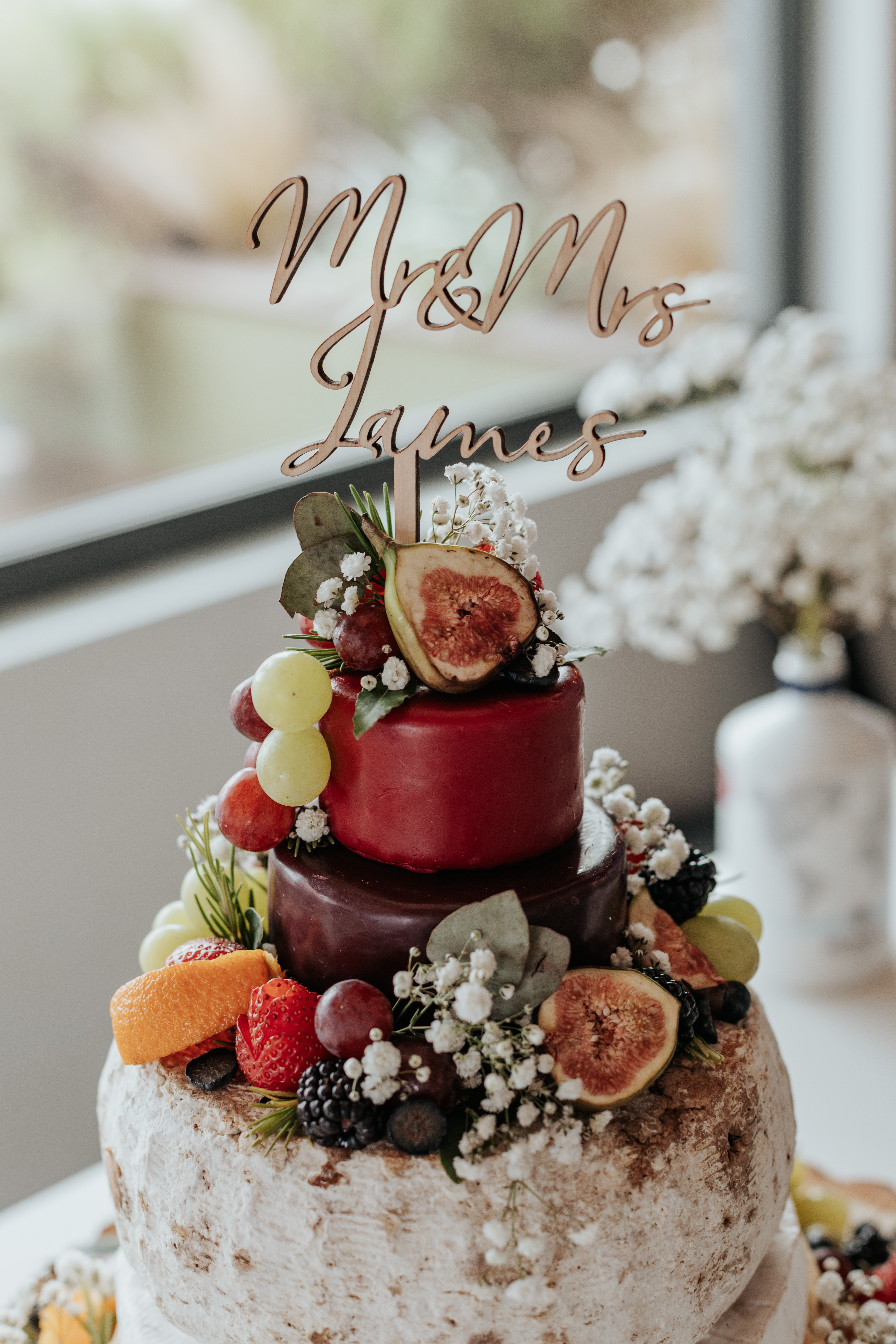 HannahSam25_07-153 A cheese wedding cake with a 'Mr & Mrs James' cake topper, with the London skyline in the background