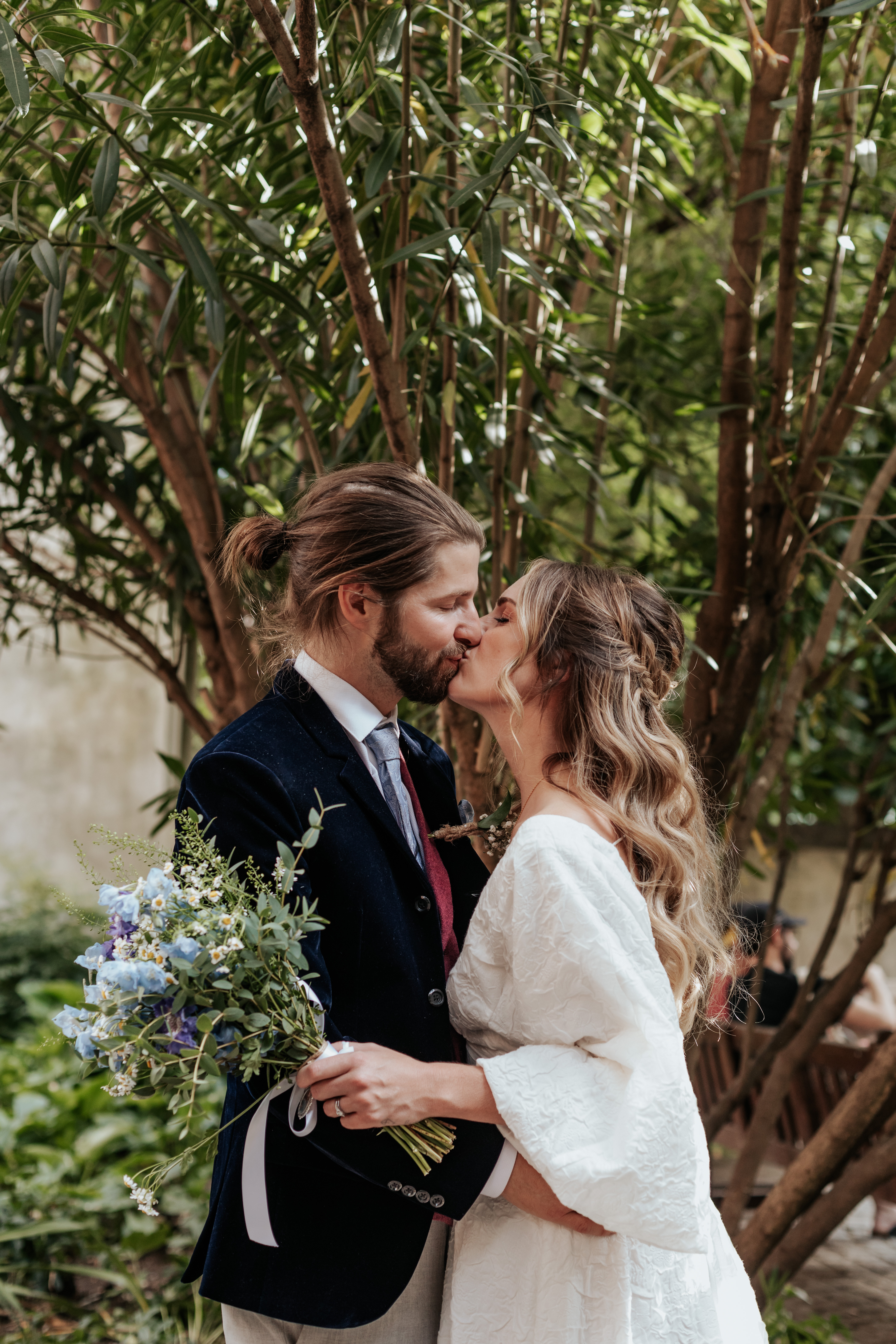 HannahSam25_07-293 Bride and groom kiss under a tree atBride and groom stand in one of the windows at St Dunstans in The East gardens during their London wedding