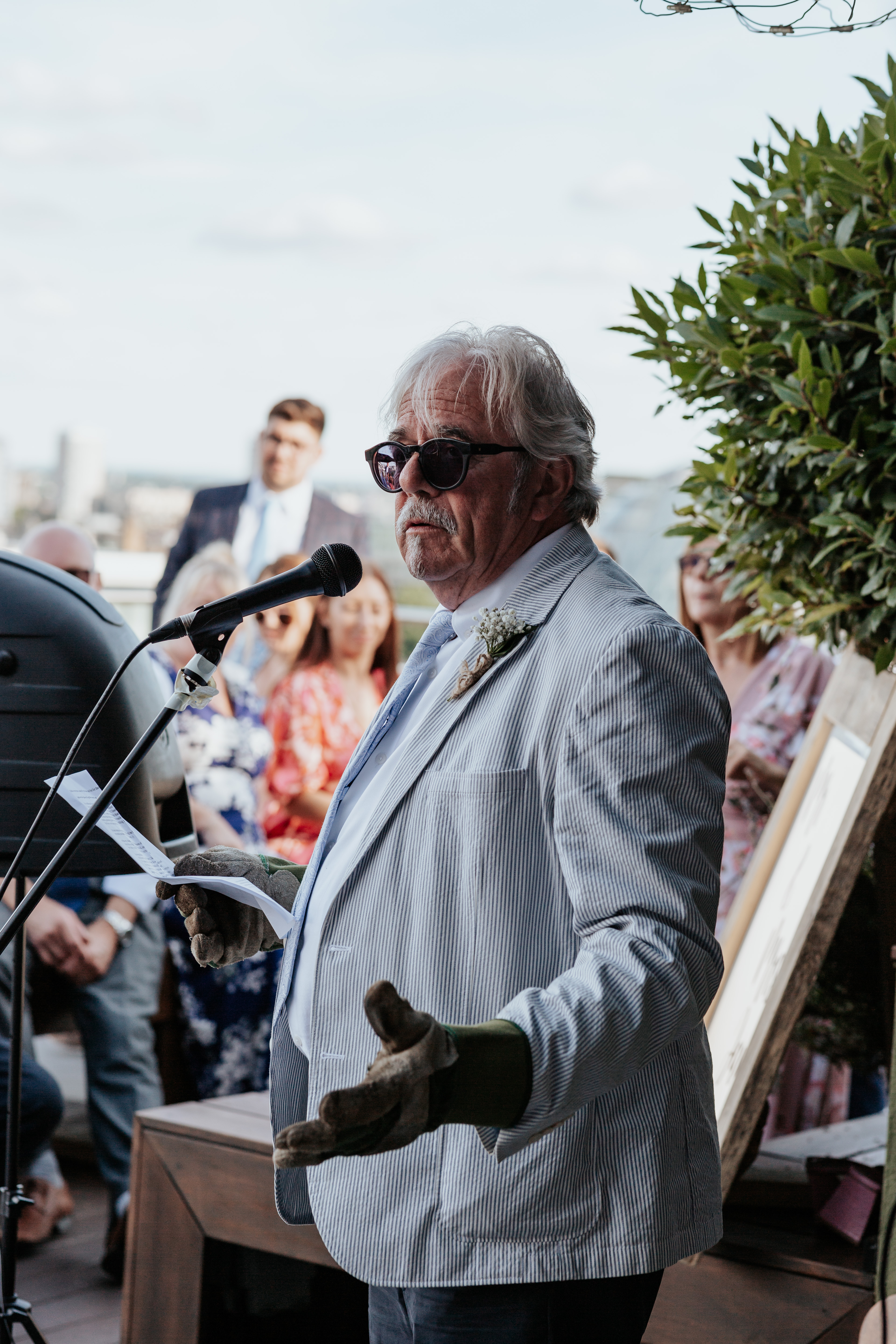 HannahSam25_07-372 Father of the bride does a speech on a London rooftop terrace while wearing gardening gloves
