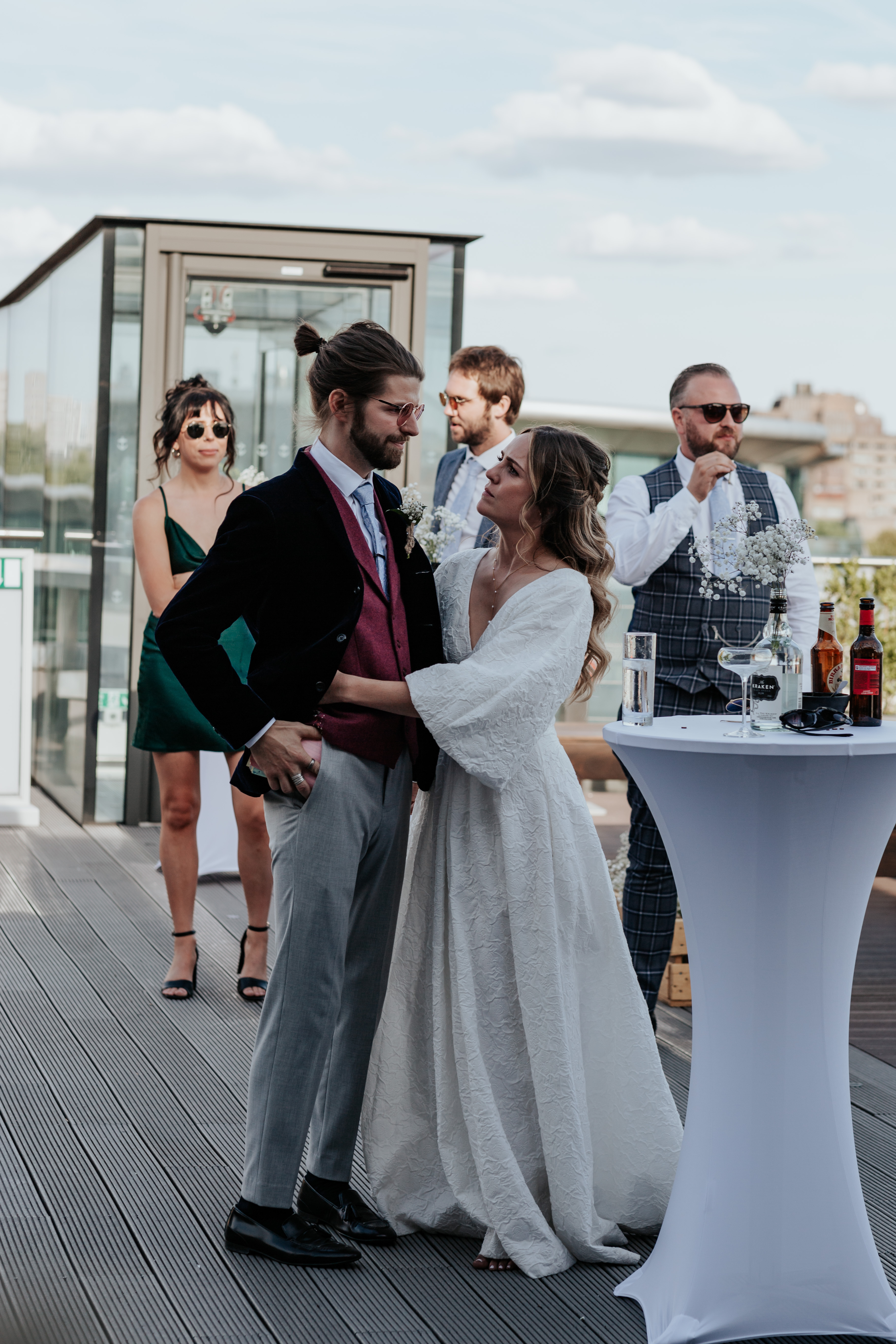 HannahSam25_07-374 Bride and groom stand together while listening to the speeches