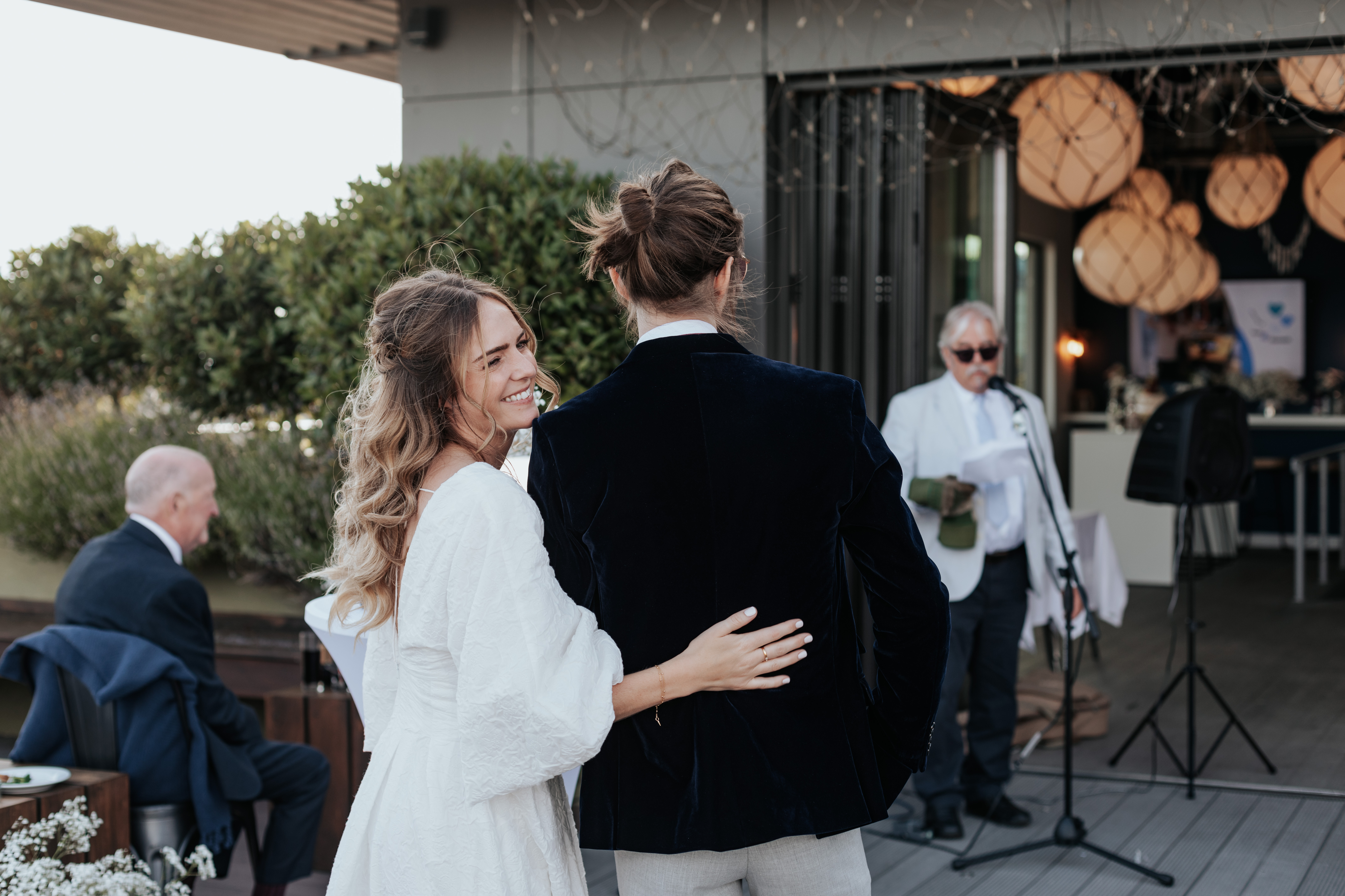 HannahSam25_07-387 Bride smiles behind her during her father's speech
