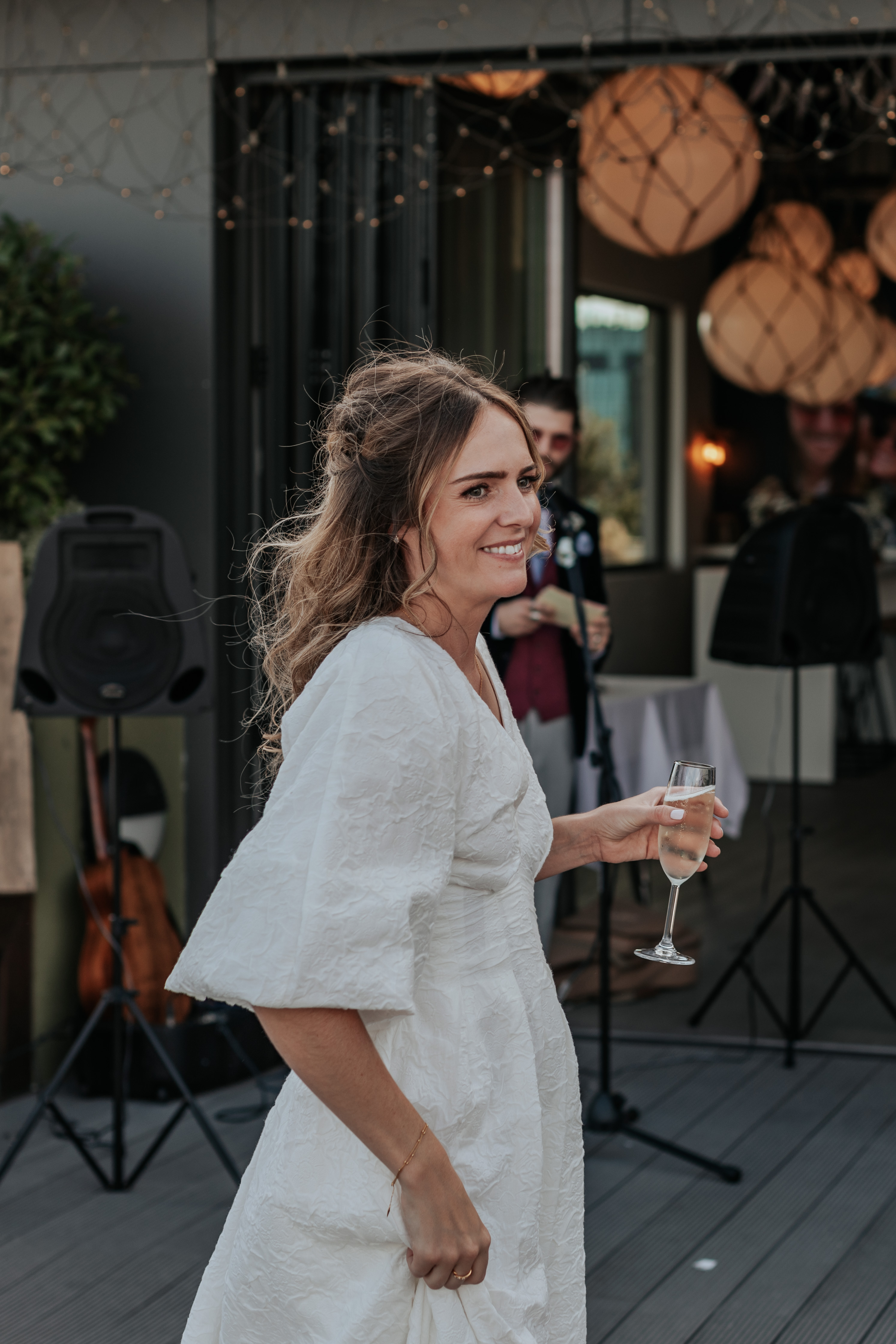 HannahSam25_07-399 Bride smiles during the groom's speech on the rooftop terrace of a London bar