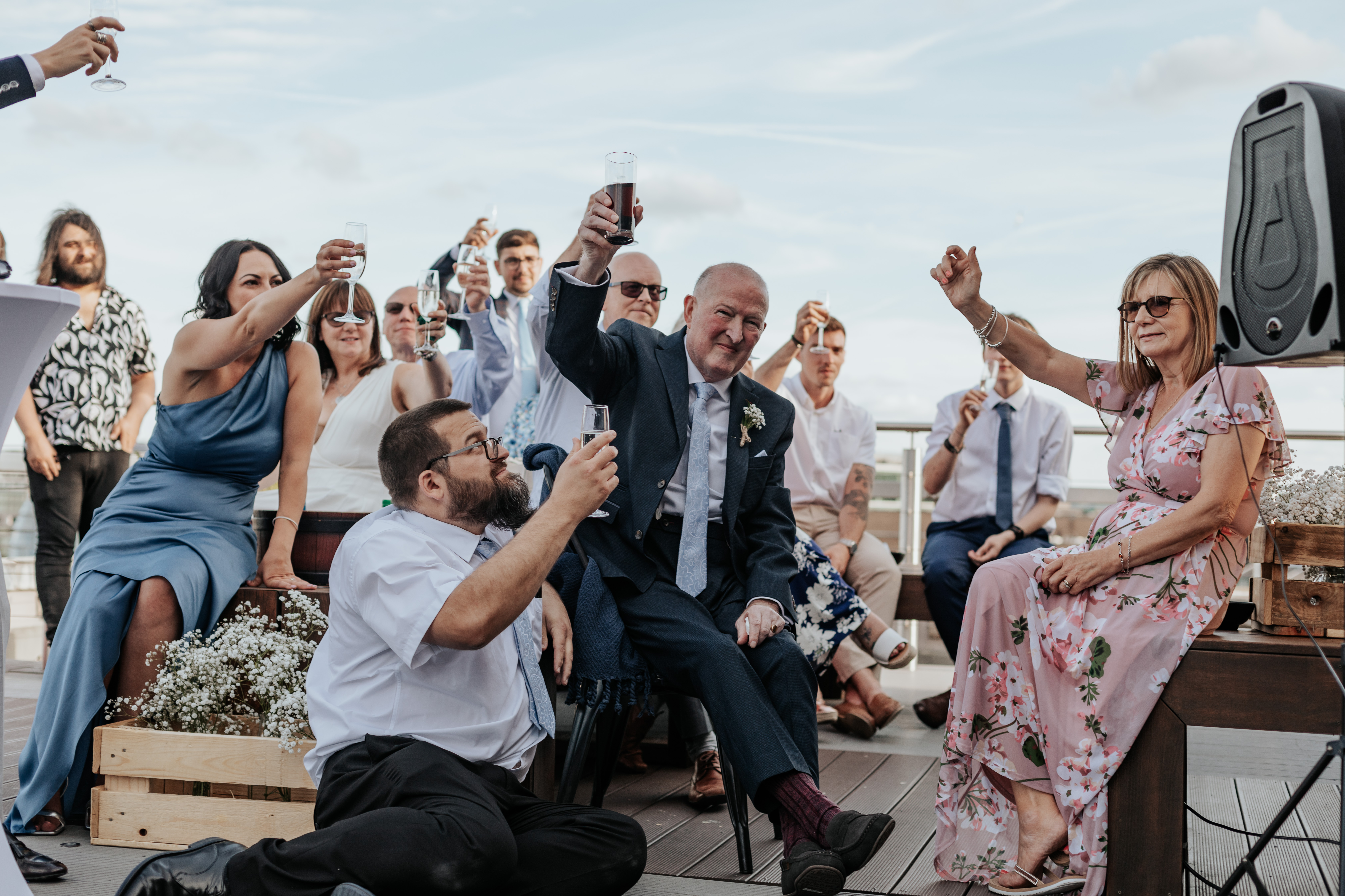 HannahSam25_07-427 Guests raise their glasses together during the speeches on the rooftop terrace of a London bar
