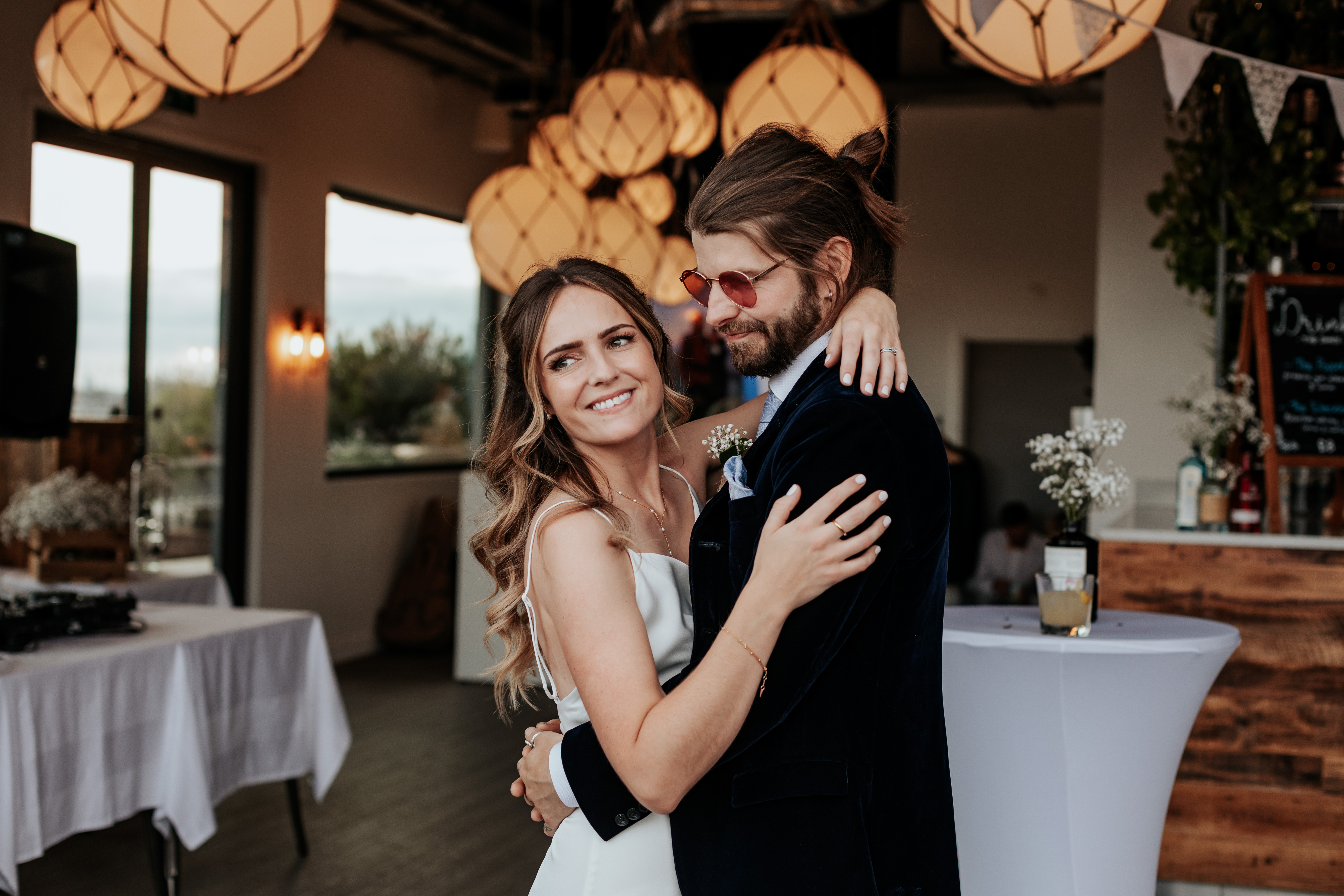 HannahSam25_07-524 Bride and groom embrace at their London wedding reception in a rooftop bar