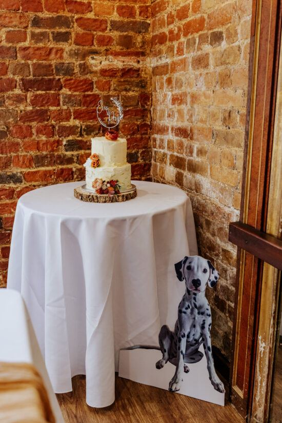 A cardboard cutout of a dalmation next to a wedding cake