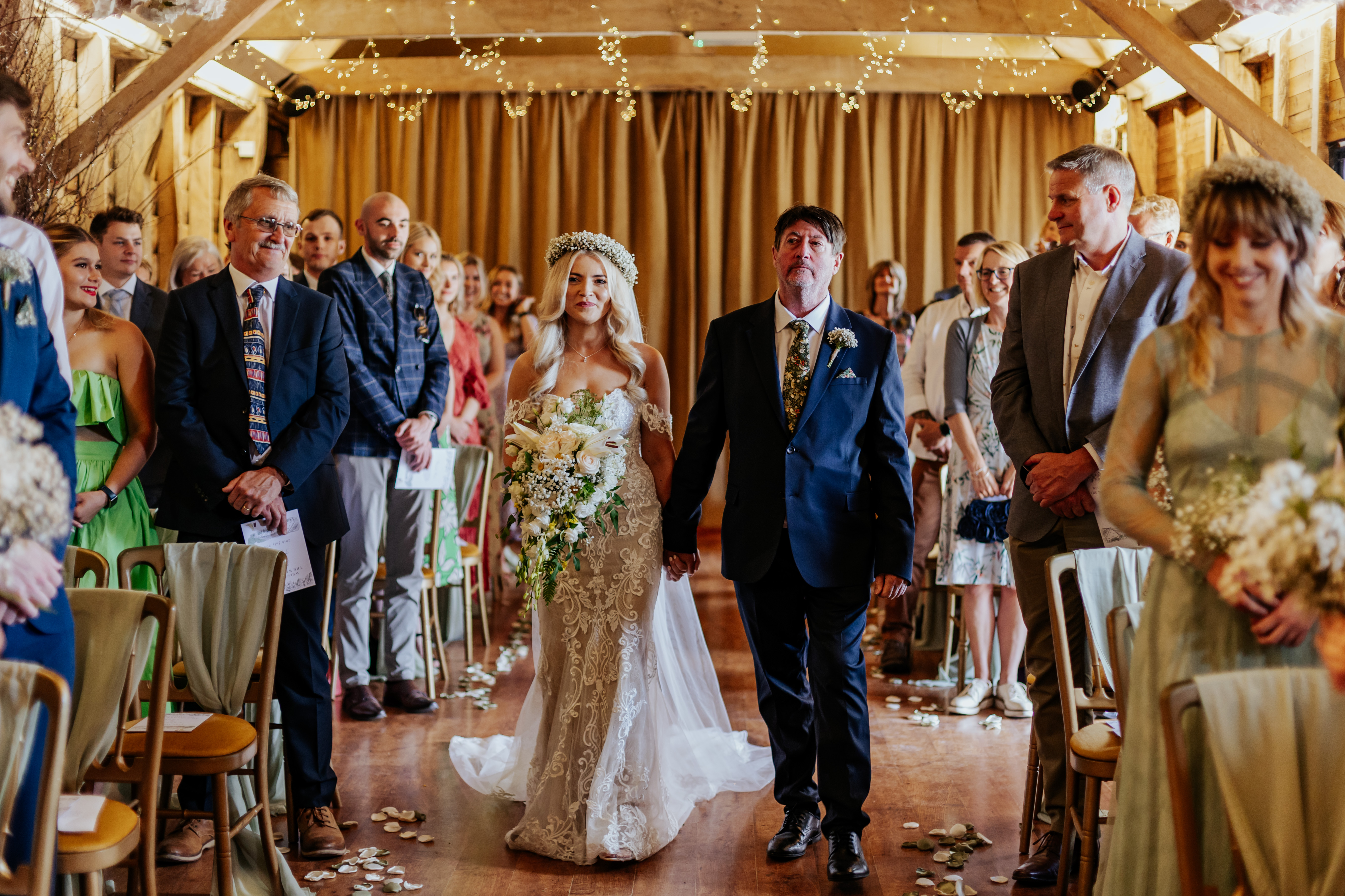 The bride walking down the aisle with her dad at Wellington Barn