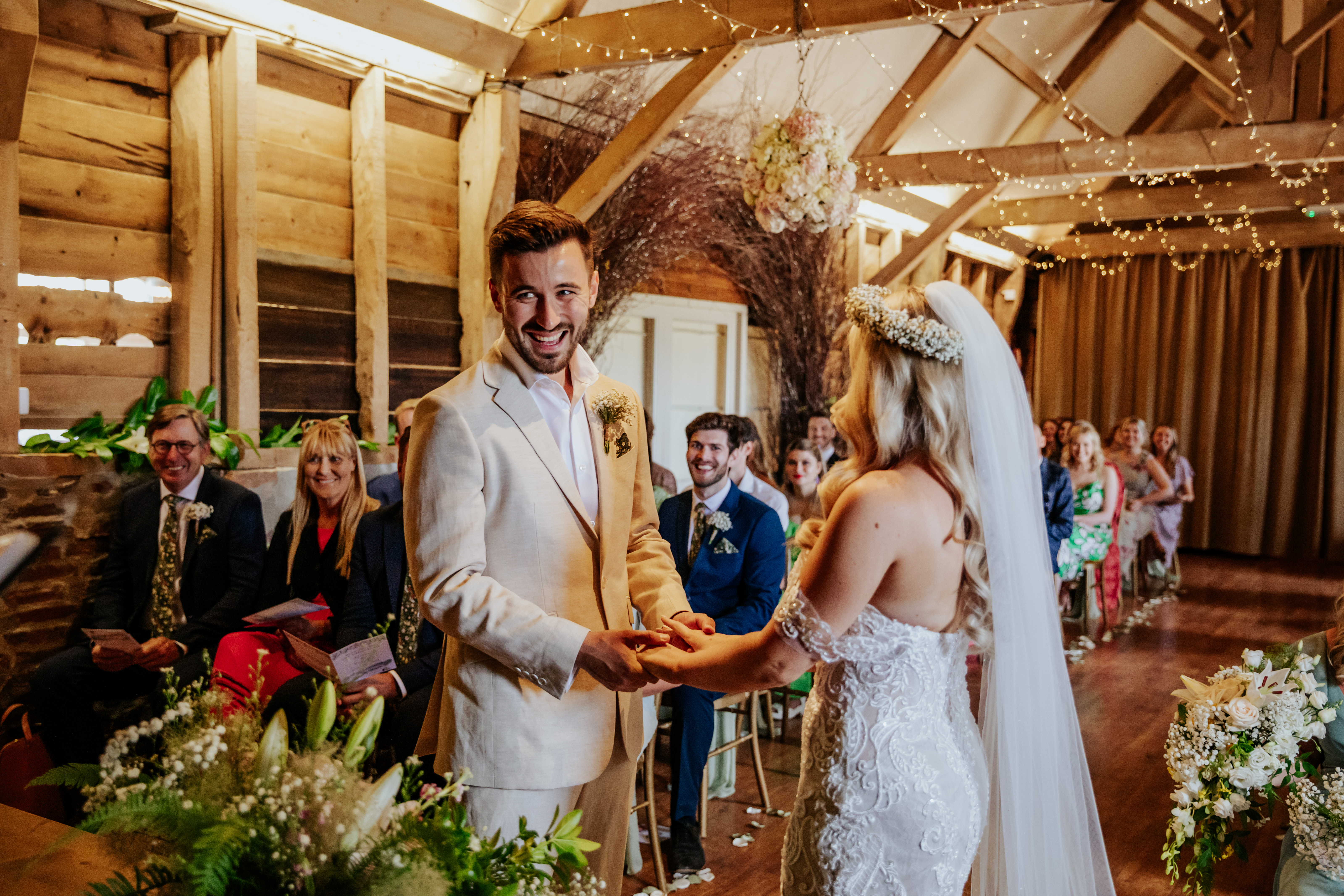 Bride and groom laugh during their ceremony in The Oak Barn at Wellington Barn