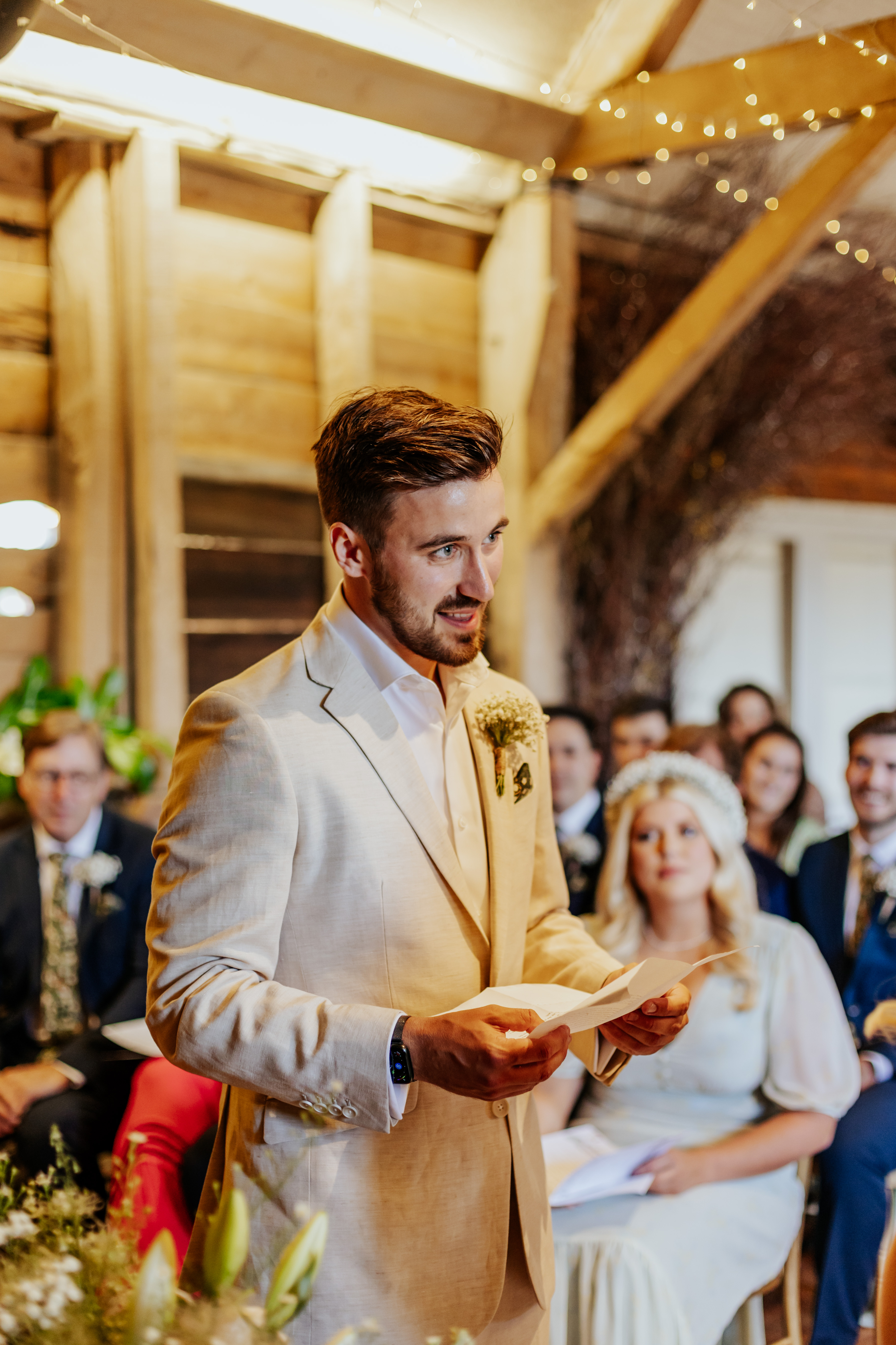 The Groom wears a cream linen suit and reads his personal vows during their wedding ceremony