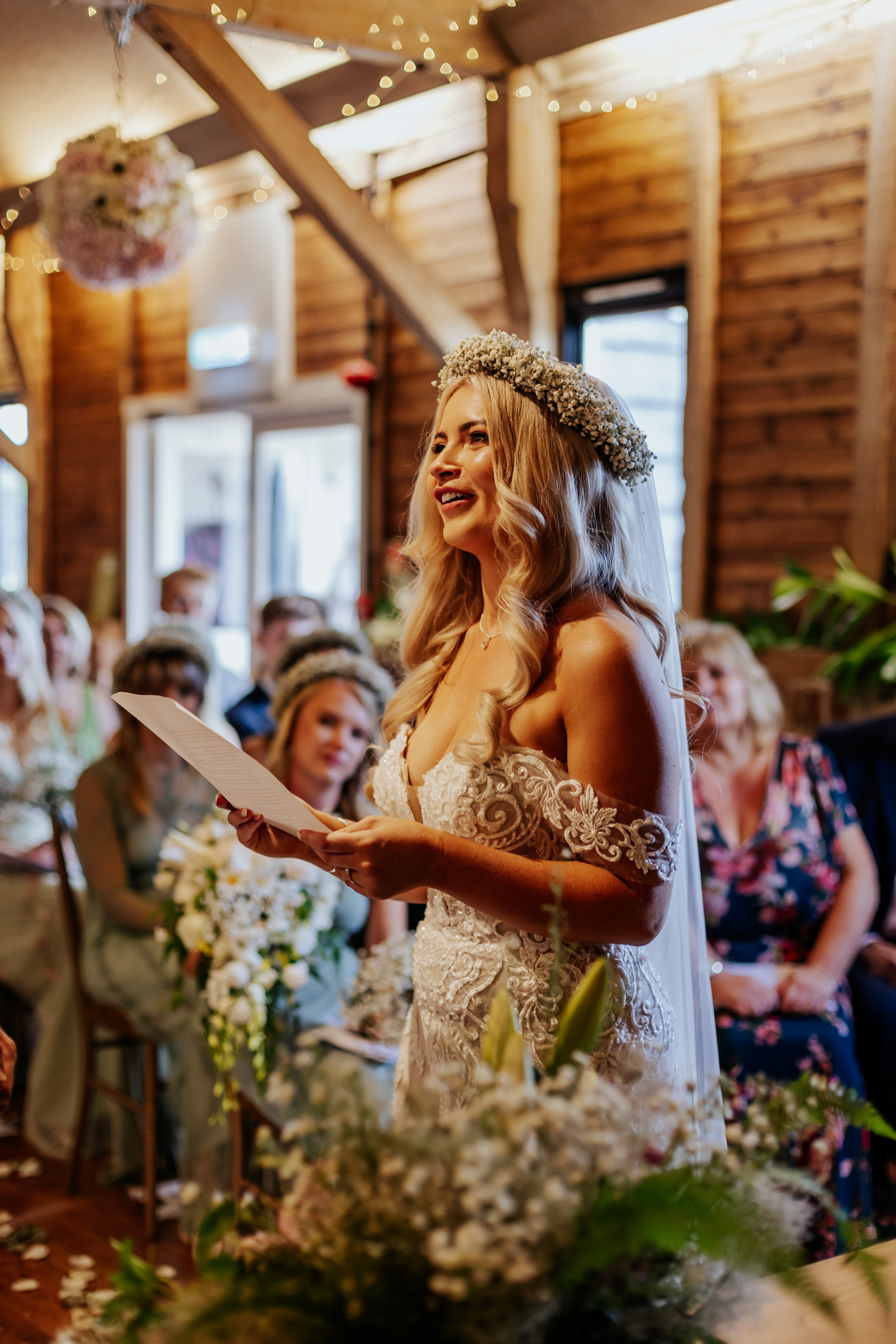 The bride reads her personal vows, surrounded by flowers during their wedding ceremony