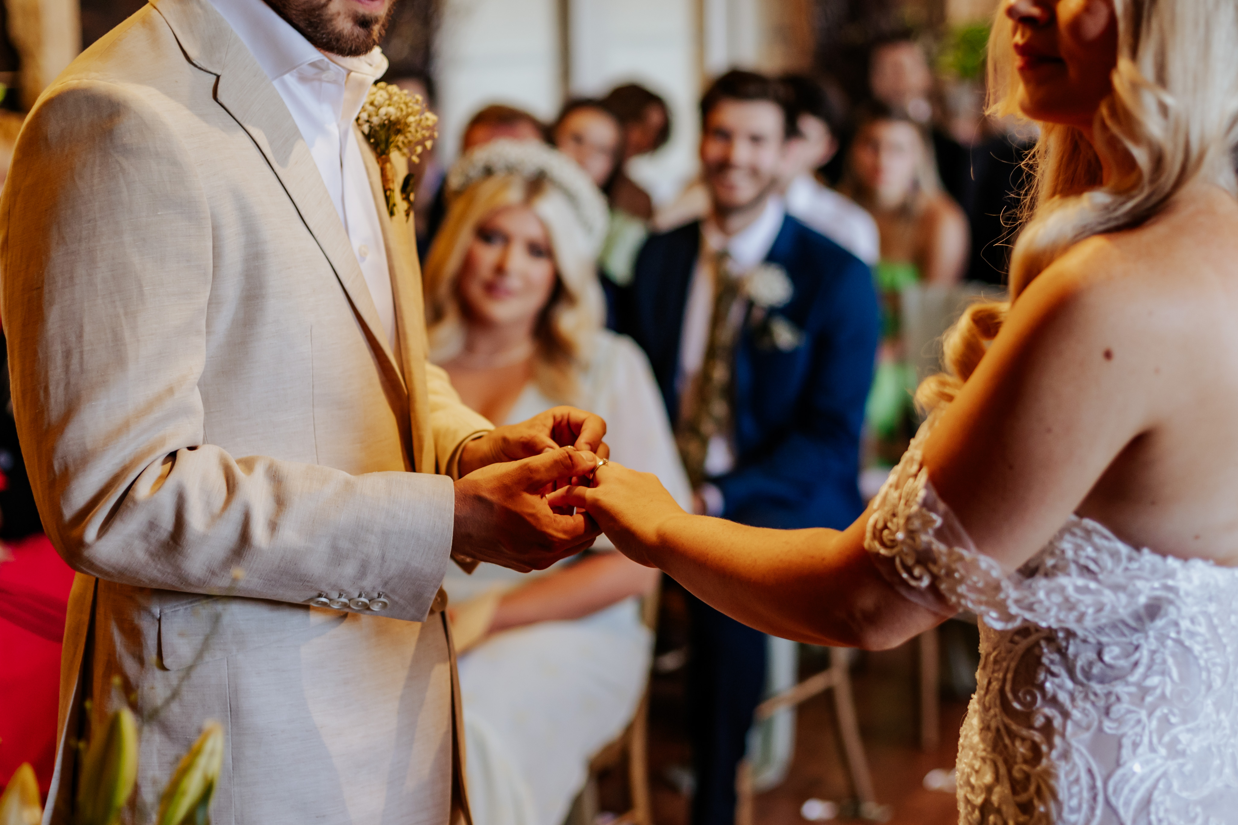 The groom puts the bride's wedding ring on her
