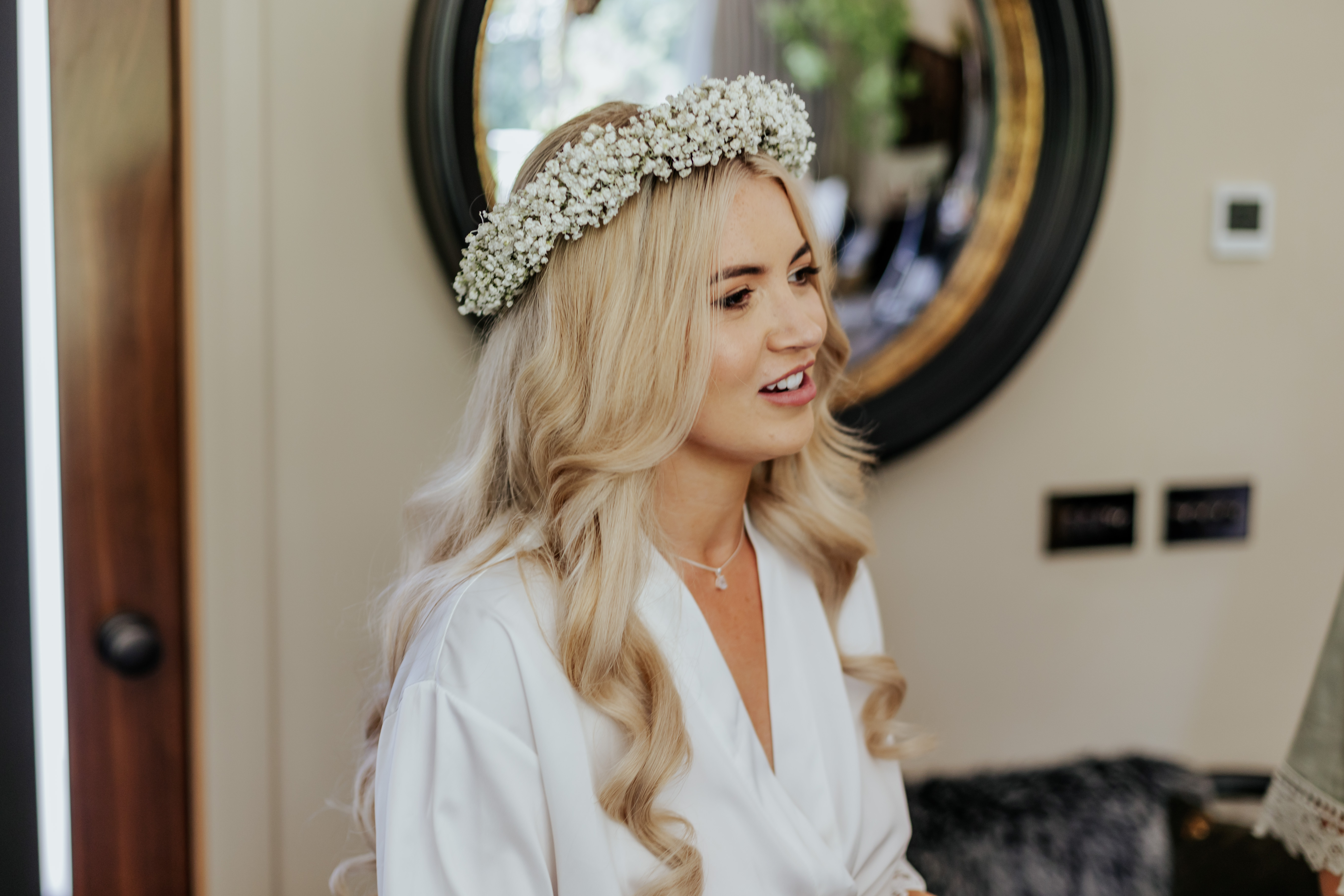 Bride Frankie in a white dressing gown with a baby's breath flower crown