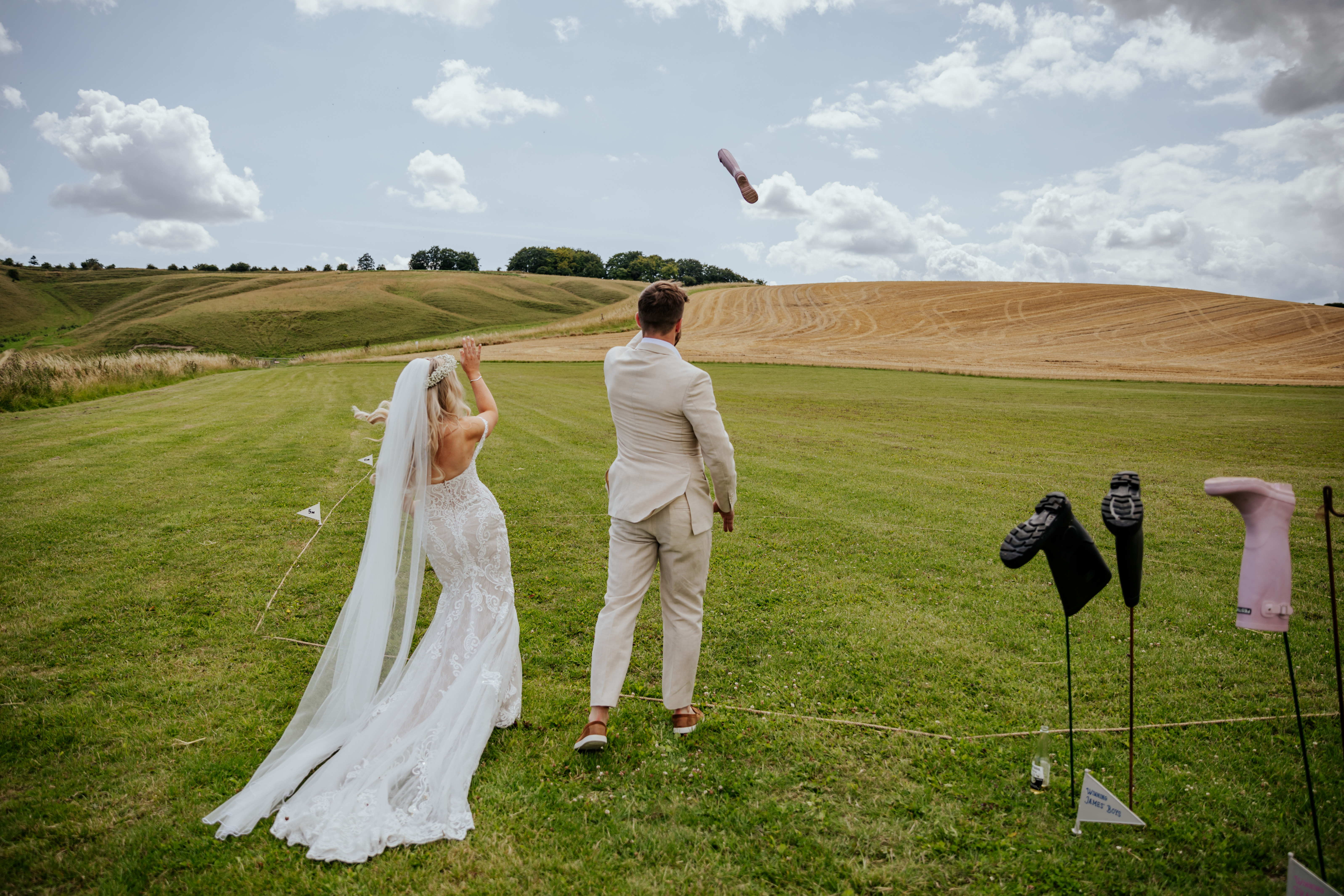 Bride and groom have a go at welly wanging during their countryside wedding