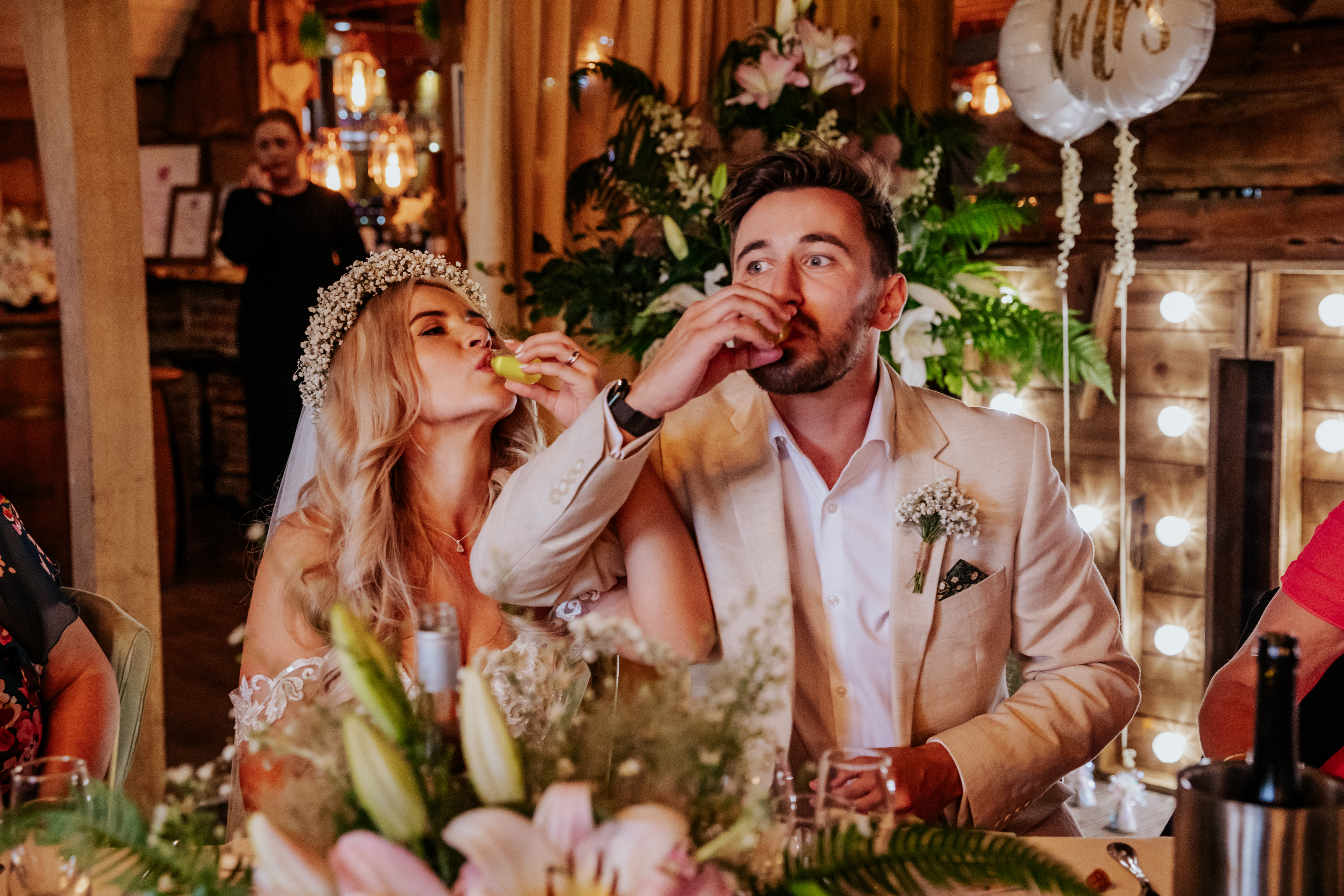 Bride and groom take a shot of limoncello together with linked arms