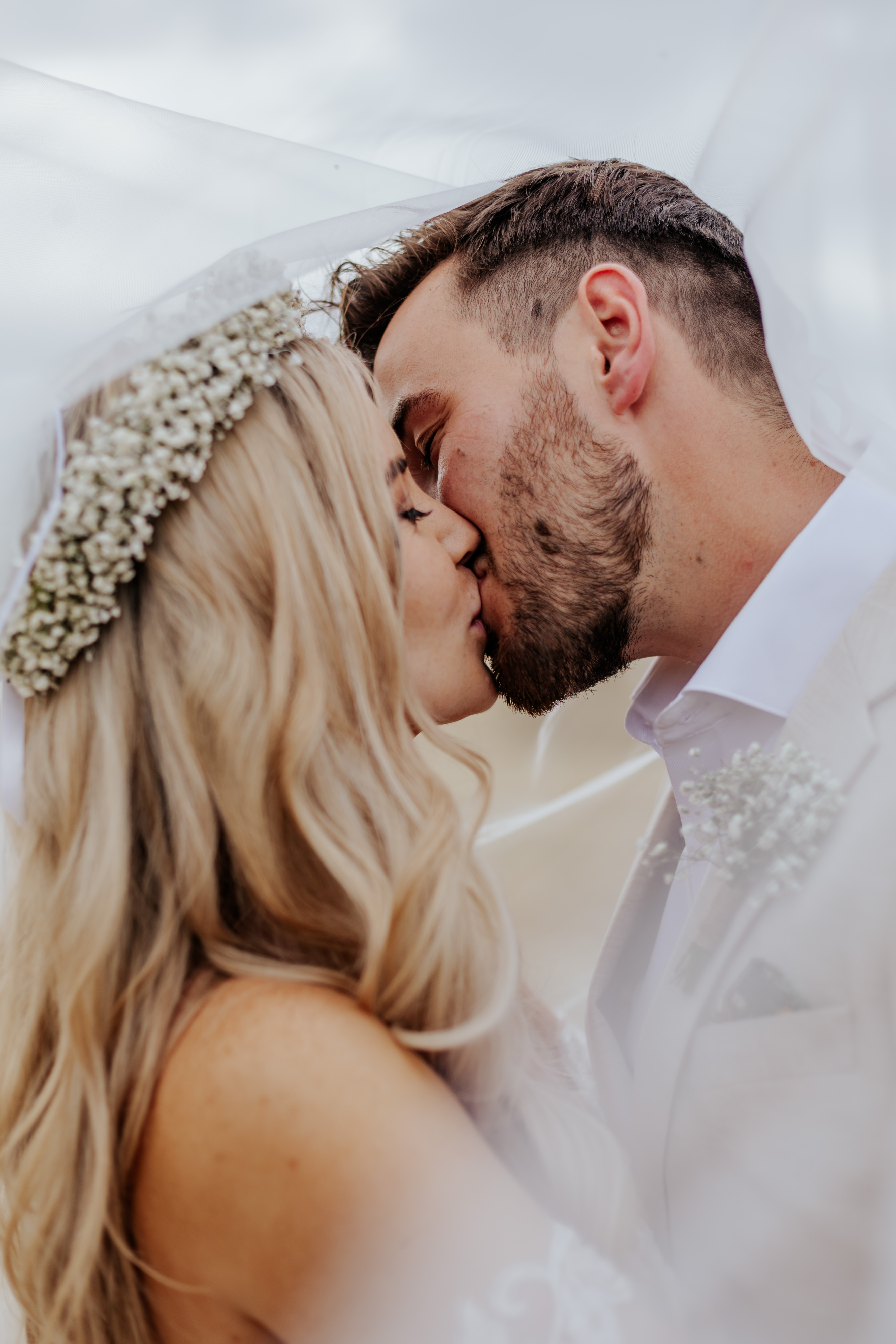 Bride and groom kiss under the veil