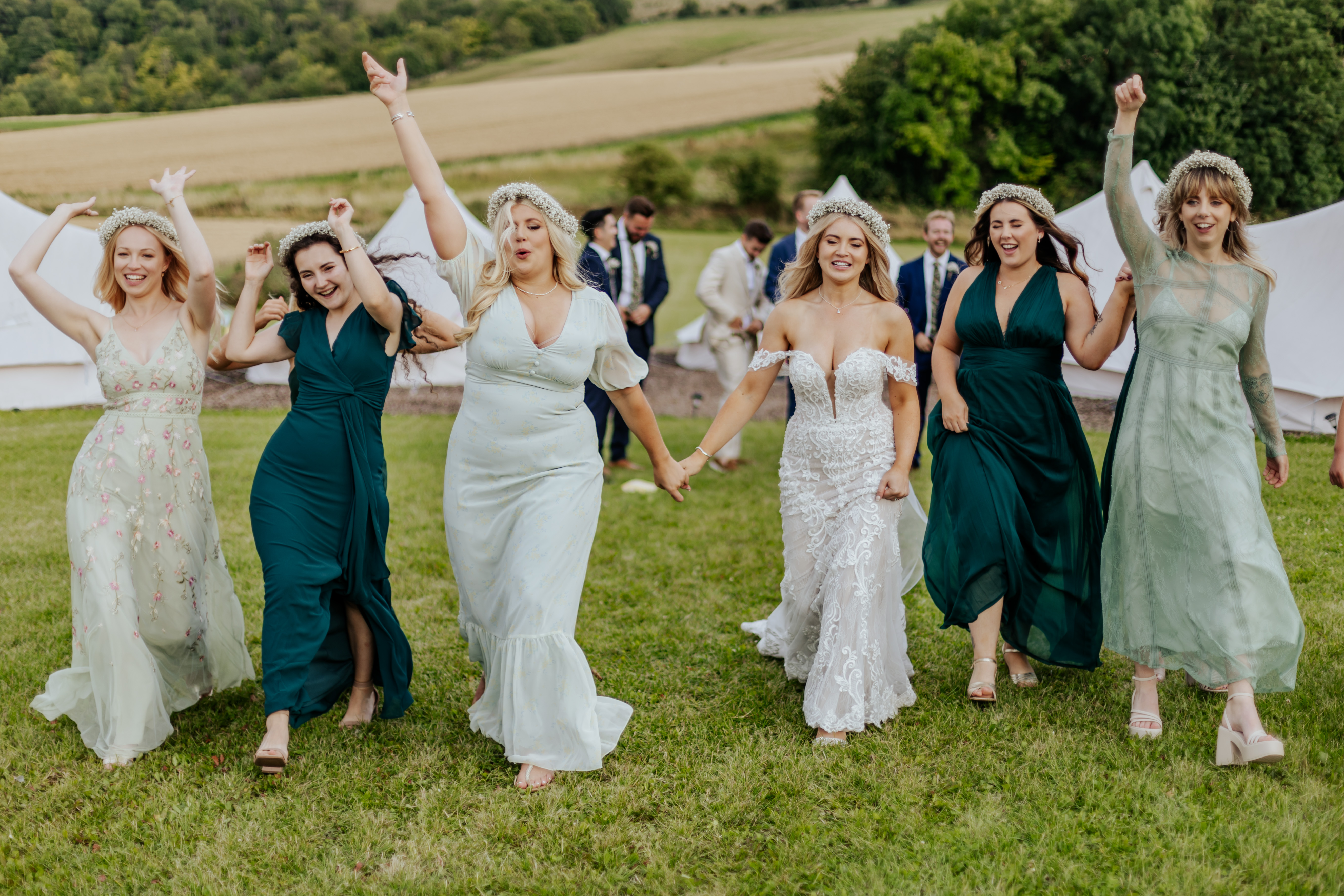 Bridesmaids hold hands and party outside of Wellington Barn's glamping pods