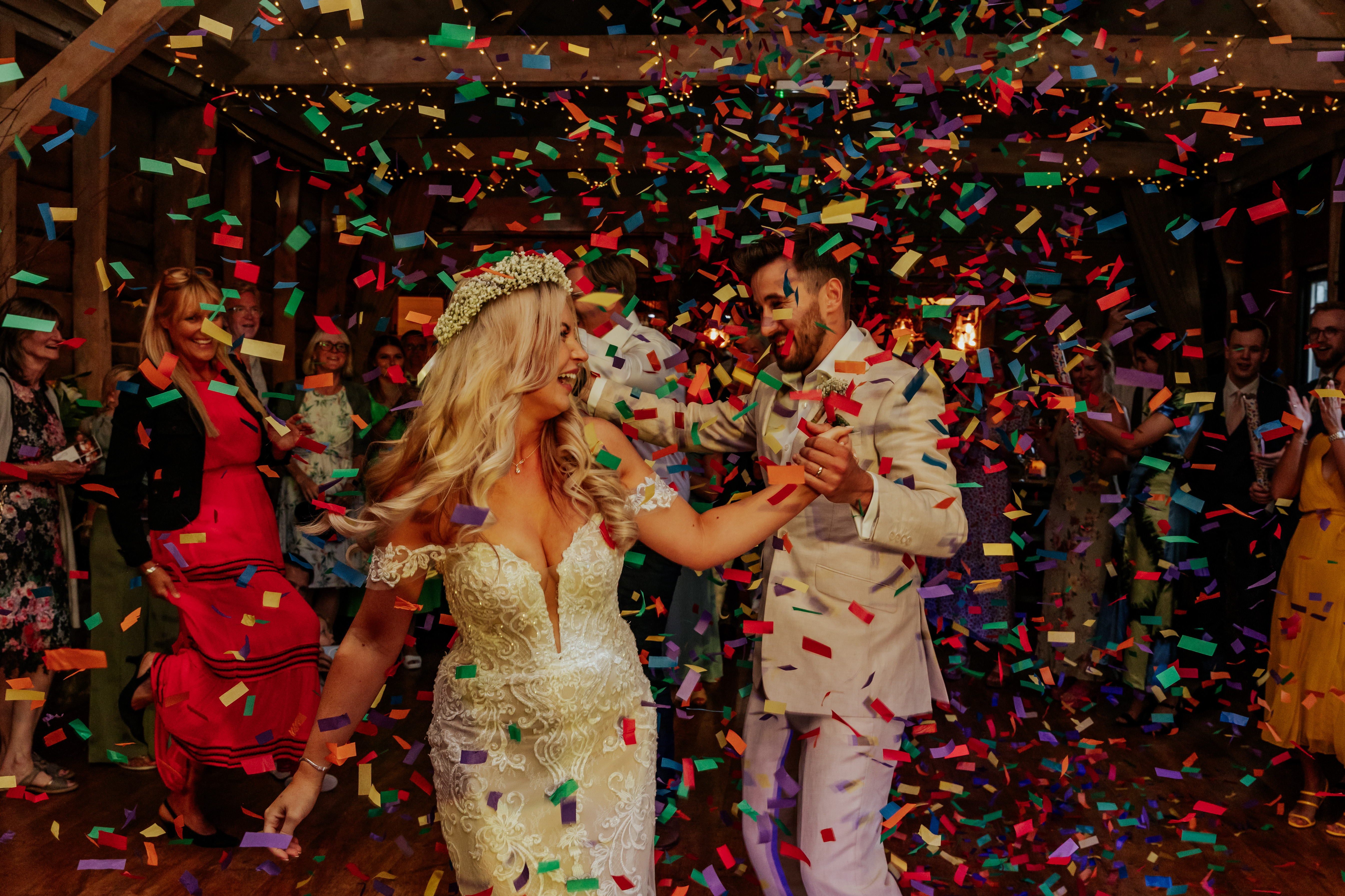 Bride and groom dance with their guests as confetti cannons go off