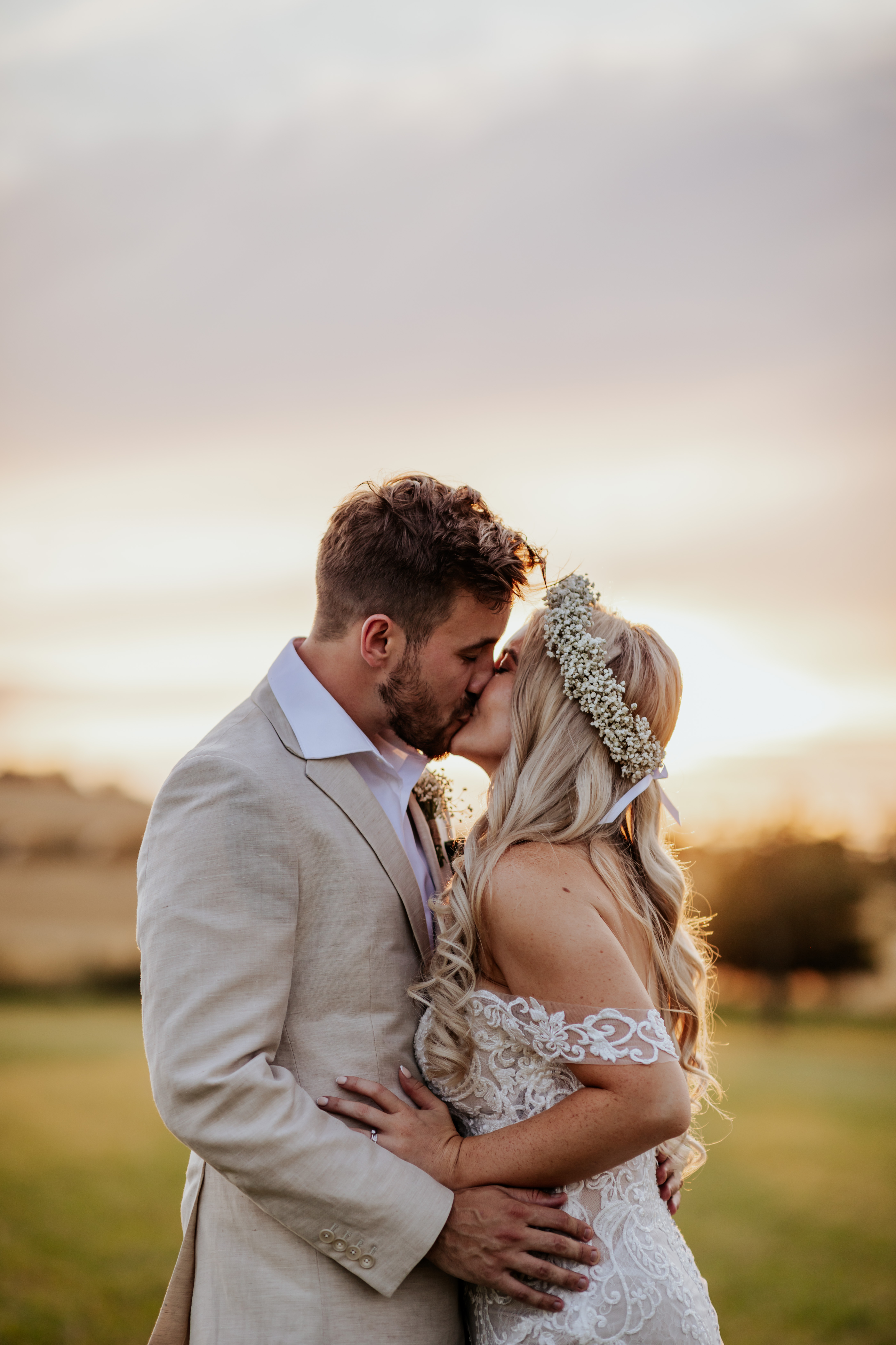 Bride and groom kiss infront of a glorious sunset at Wellington Barn